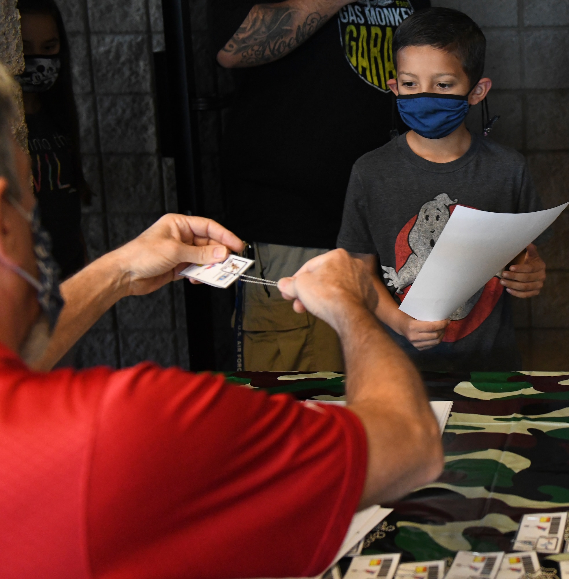 A military child receives a pretend common access card and a copy of his orders to deploy to a fictional location during Operation Kids Investigating Deployment Services, Nov. 13, 2021, at Luke Air Force Base, Arizona. Operation K.I.D.S. is an event organized by the Airman and Family Readiness Center as an educational experience to help Luke’s youth understand what is involved in deployment preparation and execution. The A&FRC takes care of Airmen and their families by providing educational resources and holding events such as Operation K.I.D.S., which gives children a better understanding of their parents’ sacrifice and dedication, and allows a dialog within families about deployments. (U.S. Air Force photo by Tech. Sgt. Amber Carter)