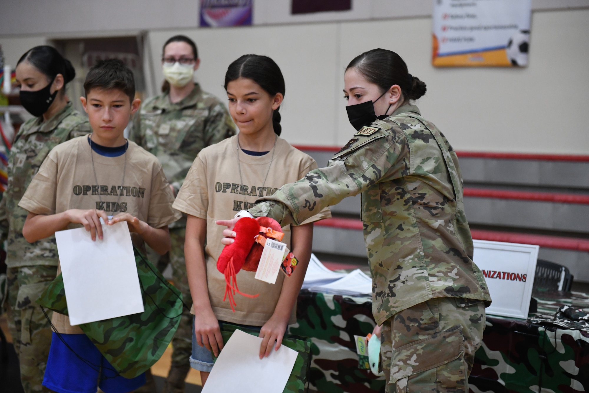 U.S. Air Force Senior Airman Gabriella Zuniga, 56th Medical Group medical technician, explains immunizations and viruses of concern to military children during Operation Kids Investigating Deployment Services Nov. 13, 2021, at Luke Air Force Base, Arizona. Operation K.I.D.S. is an event that included a mock pre-deployment line with visits to finance, medical, the American Red Cross, key spouse and chapel personnel, as an imitation of what their parents experience prior to deploying. The Airman and Family Readiness Center takes care of Airmen and their families by providing educational resources and holding events such as Operation K.I.D.S., which gives children a better understanding of their parents’ sacrifice and dedication, and allows a dialog within families about deployments. (U.S. Air Force photo by Tech. Sgt. Amber Carter)