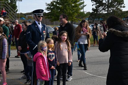 A member of the United States Air Force Honor Guard Drill Team poses with children attending a military immersion event held on Joint Base Anacostia-Bolling, Washington, D.C., Nov. 6, 2021. U.S. Air Force, Army and Coast Guard members held demonstrations for the military and civilian students to learn about military customs and courtesies while increasing their understanding of the military lifestyle. The event was coordinated by the Brent Elementary School Parent-Teacher Association to educate and immerse children into military culture. (U.S. Air Force photo by Airman 1st Class Anna Smith)