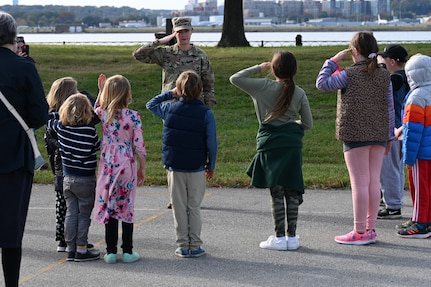 U.S. Army Staff Sgt. Jessica Kelley, administrative NCO to the sergeant major of the Army, teaches a group of Brent Elementary School students how to salute during a military immersion event on Joint Base Anacostia-Bolling, Washington, D.C., Nov. 6, 2021. U.S. Air Force, Army and Coast Guard members held demonstrations for the military and civilian students to learn about military customs and courtesies while increasing their understanding of the military lifestyle.   Kelley taught students basic military drill and stationary movements. JBAB hosted this event to support the ongoing effort to foster understanding and support between the military and civilian communities. (U.S. Air Force photo by Airman 1st Class Anna Smith)