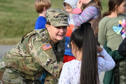 U.S. Army Staff Sgt. Jessica Kelley, administrative NCO to the sergeant major of the Army, teaches a Brent Elementary School student how to salute during a military immersion event on Joint Base Anacostia-Bolling, Washington, D.C., Nov. 6, 2021. U.S. Air Force, Army and Coast Guard members held demonstrations for the military and civilian students to learn about military customs and courtesies while increasing their understanding of the military lifestyle. Kelley taught students basic military drill and stationary movements. JBAB hosted this event to support the ongoing effort to foster understanding and support between the military and civilian communities. (U.S. Air Force photo by Airman 1st Class Anna Smith)