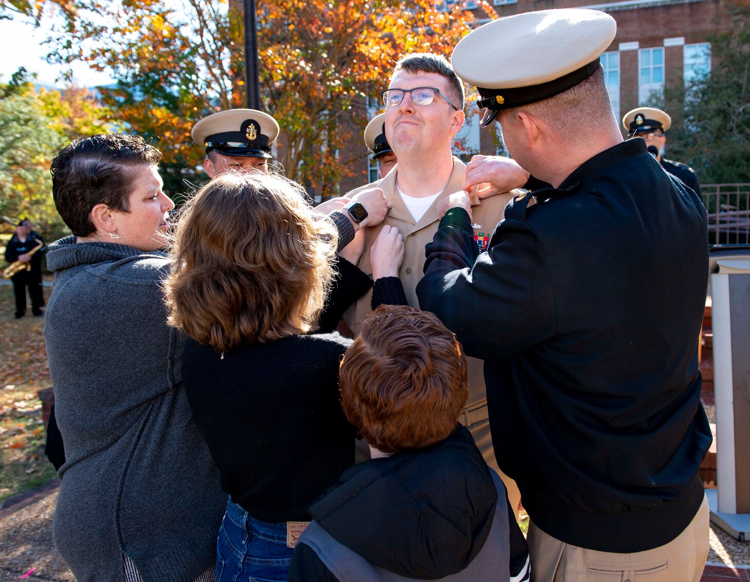 Chief Mass Communication Specialist Gary Johnson is overcome with emotion as his family and mentor pin on his anchors during the chief petty officer pinning ceremony at POW/MIA Park, Nov. 19, 2021.