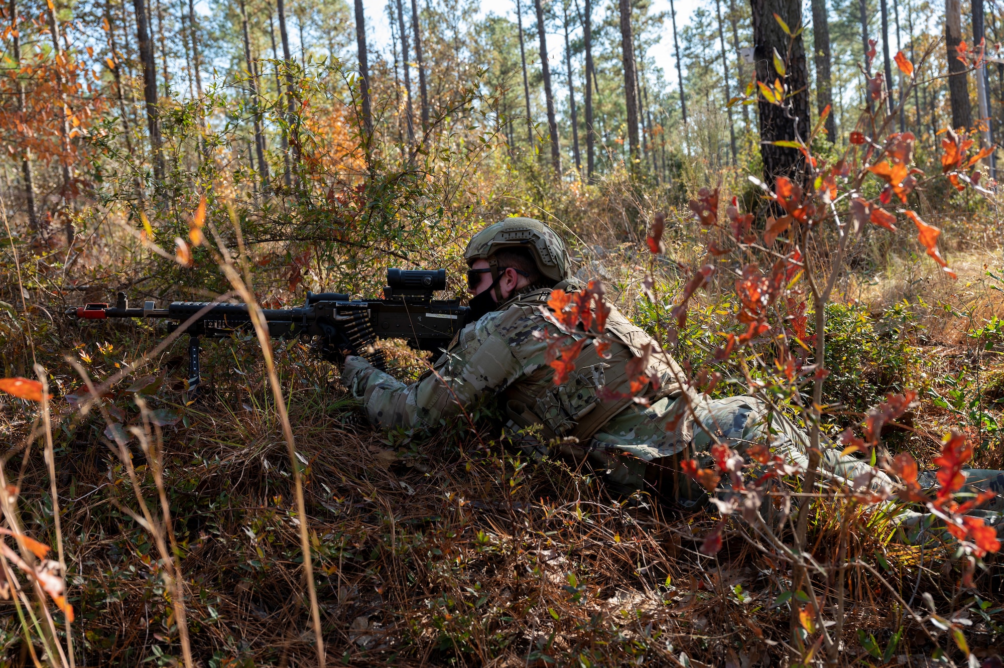 An Airman lays in some leaves during an exercise