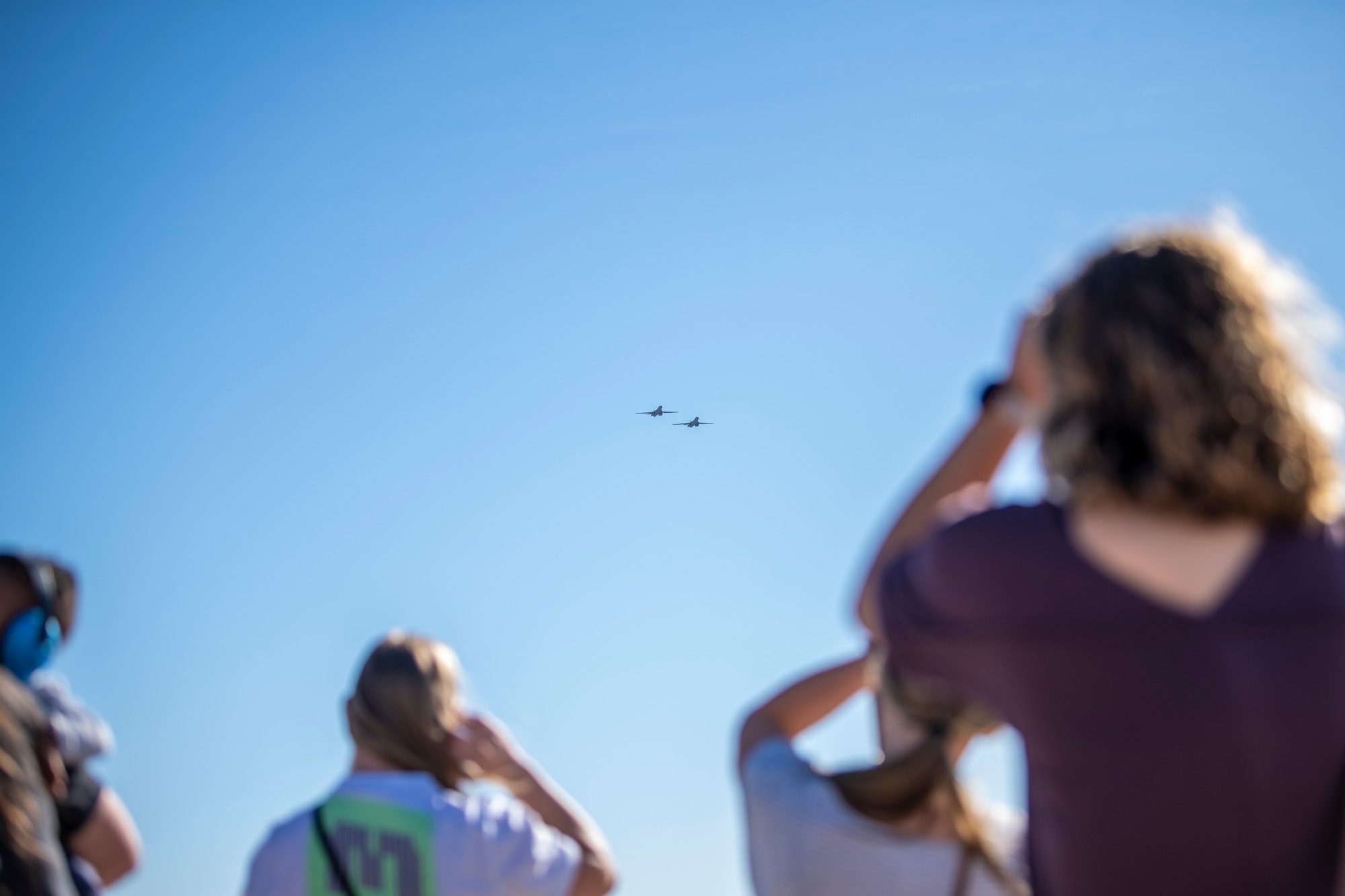 Families from the 9th Bomb Squadron watch two B-1B Lancers fly overhead at Dyess Air Force Base, Texas, Nov. 14, 2021.