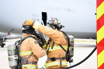 902nd Civil Engineer Squadron firefighters prepare to enter a 433rd Airlift Wing C-5M Super Galaxy during an exercise to simulate a brake fire Nov. 18, 2021, at Joint Base San Antonio-Lackland, Texas. The total force exercise provided firefighters with hands-on aircraft and crew egress-procedure training. (U.S. Air Force photo by Master Sgt. Kristian Carter)