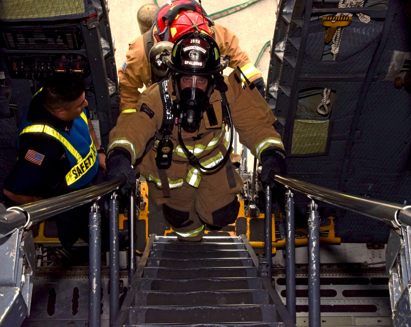 Jake Spalding and Leonard Gerlich, 902nd Civil Engineer Squadron firefighters, ascend stairs leading to a C-5M Super Galaxy flight deck to check for simulated incapacitated aircrew members during an exercise Nov. 18, 2021, at Joint Base San Antonio-Lackland, Texas. During the event, firefighters simulated extinguishing a main landing gear brake fire and assisting the aircrew with evacuating the aircraft. (U.S. Air Force photo by Samantha Mathison)