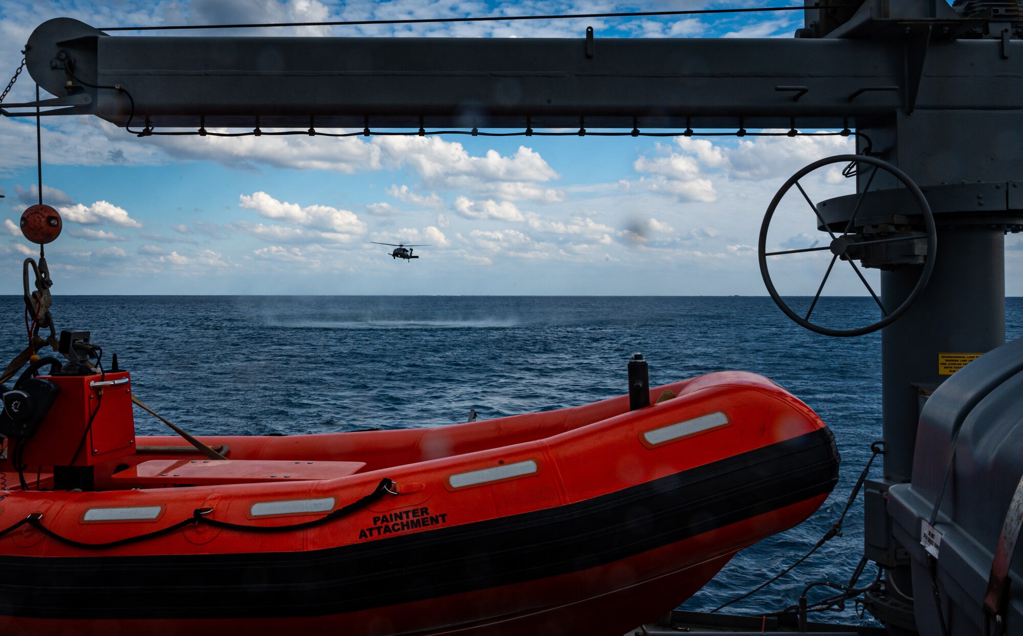 A helicopter flies over the ocean.
