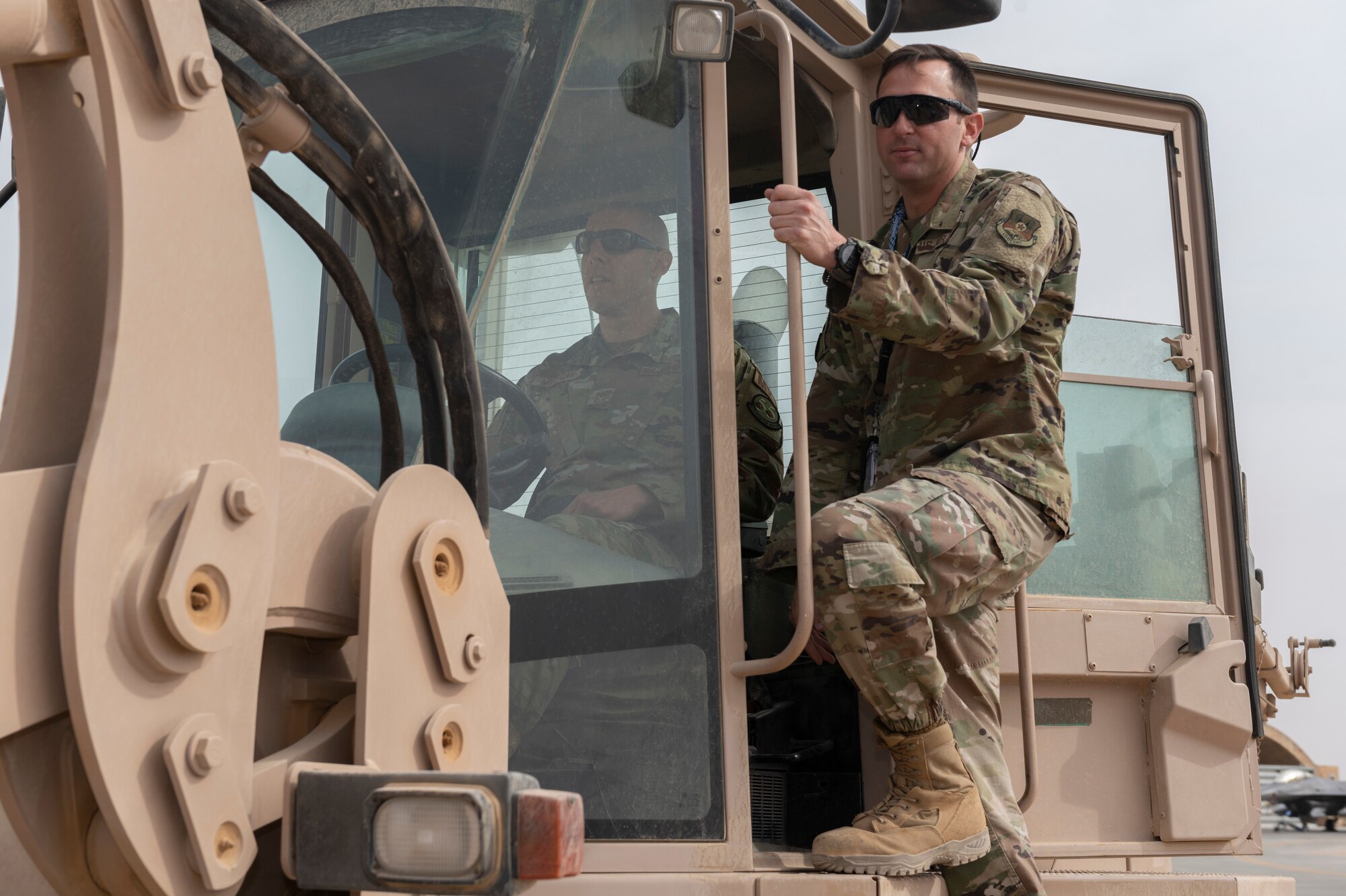 U.S. Air Force Chief Master Sgt. Sean Milligan, left, 332nd Air Expeditionary Wing command chief, operates a forklift while Master Sgt. Nathaniel Gladney, 55th Expeditionary Fighter Generation Squadron support section chief, guides him Nov. 13, 2021, at an undisclosed location somewhere in Southwest Asia. The 55th EFGS store and inspect equipment for five maintenance sections responsible for maintaining F-16C Fighting Falcons. (U.S. Air Force photo by Senior Airman Cameron Otte)