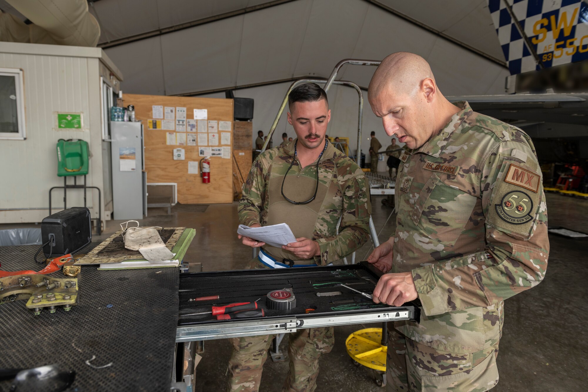 U.S. Air Force Airman 1st Class John Ferguson, left, 55th Expeditionary Fighter Generation Squadron support technician, runs through a toolbox check with Chief Master Sgt. Sean Milligan, 332nd Air Expeditionary Wing command chief, Nov. 13, 2021, at an undisclosed location somewhere in Southwest Asia. The 55th EFGS store and inspect equipment for five maintenance sections responsible for maintaining F-16C Fighting Falcons. (U.S. Air Force photo by Senior Airman Cameron Otte)