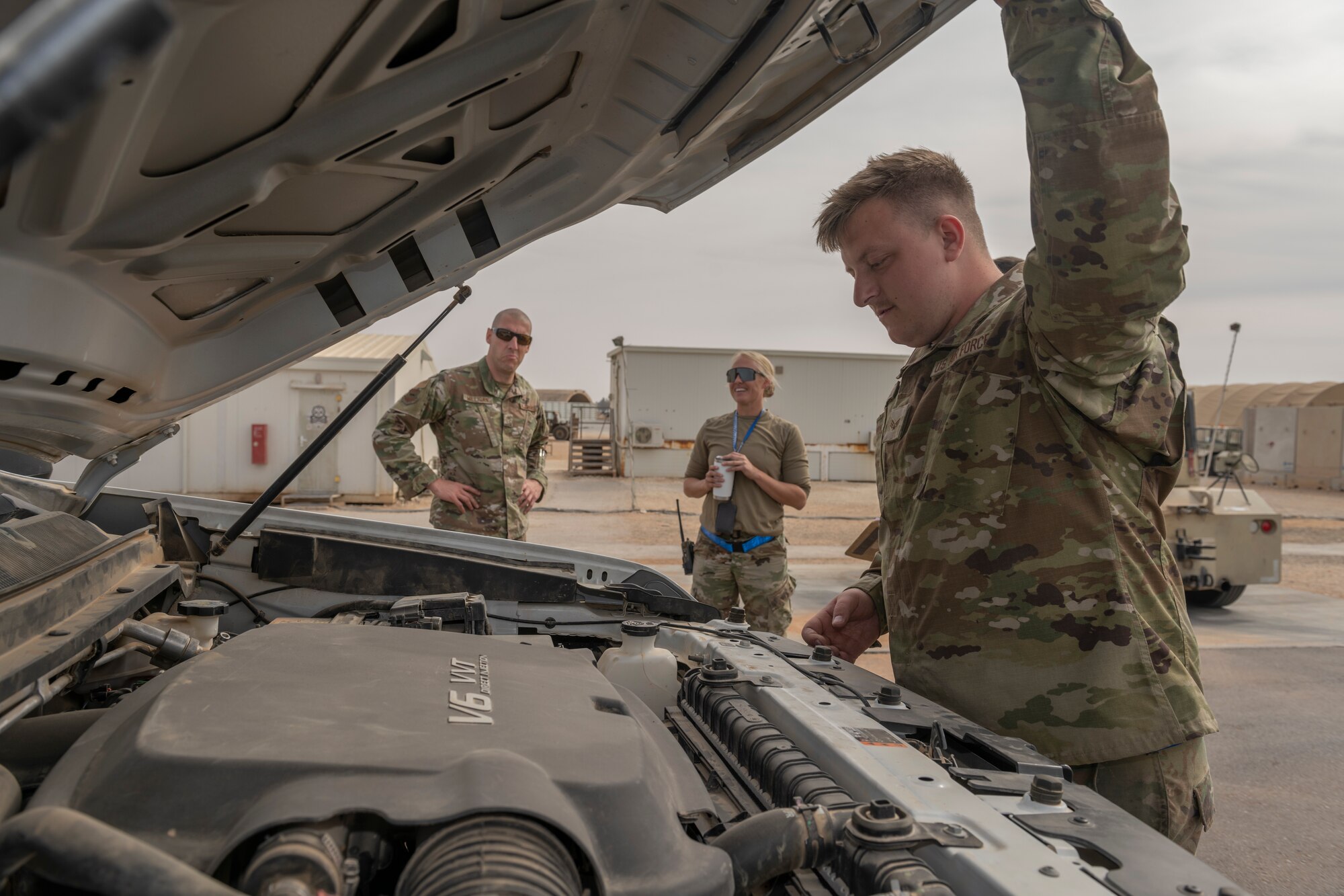 U.S. Air Force Senior Airman Christopher Hites, right, 55th Expeditionary Fighter Generation Squadron support technician, shows Chief Master Sgt. Sean Milligan, 332nd Air Expeditionary Wing command chief, left, how to perform a vehicle inspection