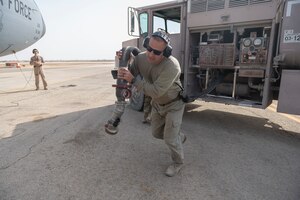 U.S. Air Force Tech. Sgt. Mitchell Madeker, 332nd Expeditionary Logistics Readiness Squadron noncommissioned officer in charge of fuel distribution, pulls a fuel hose out of an R-11 fuel truck
