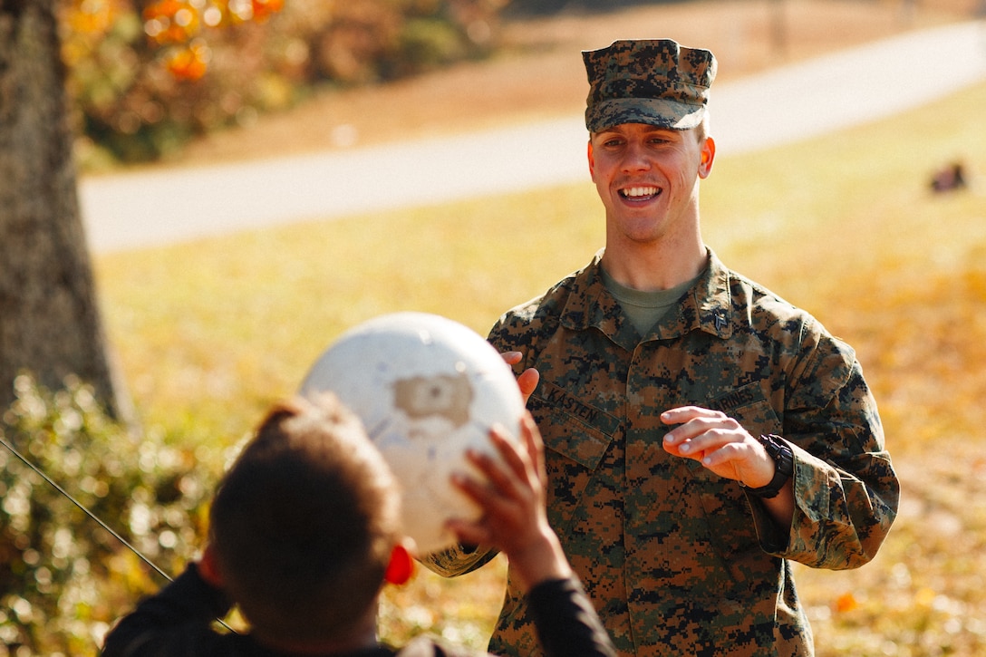 U.S. Marine Corps Cpl. Dylan Kasten, a mortarman with 1st Battalion, 23rd Marine Regiment, plays with an Afghan child on Fort Pickett, Virginia, Nov. 17, 2021.