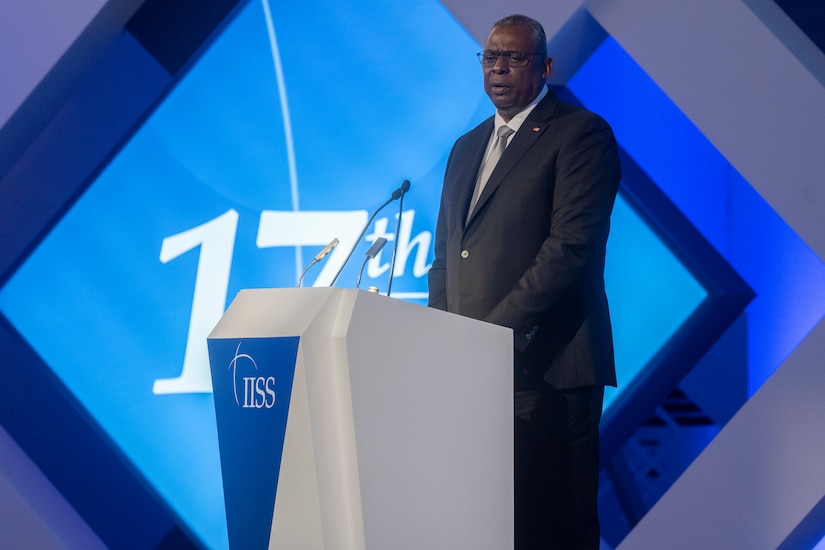 A man standing at a lectern delivers a speech.