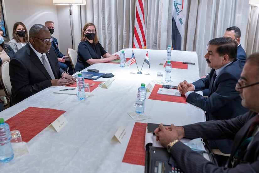 Men and a woman are seated at a table to exchange information.