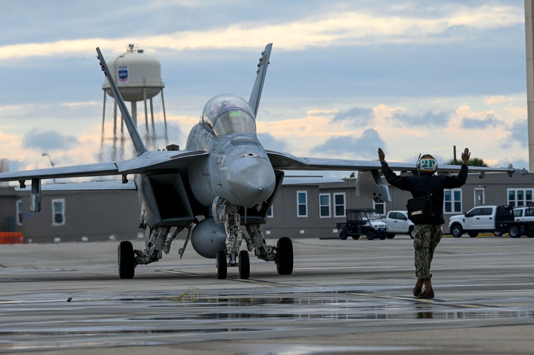 A sailor marshals an F-18 pilot