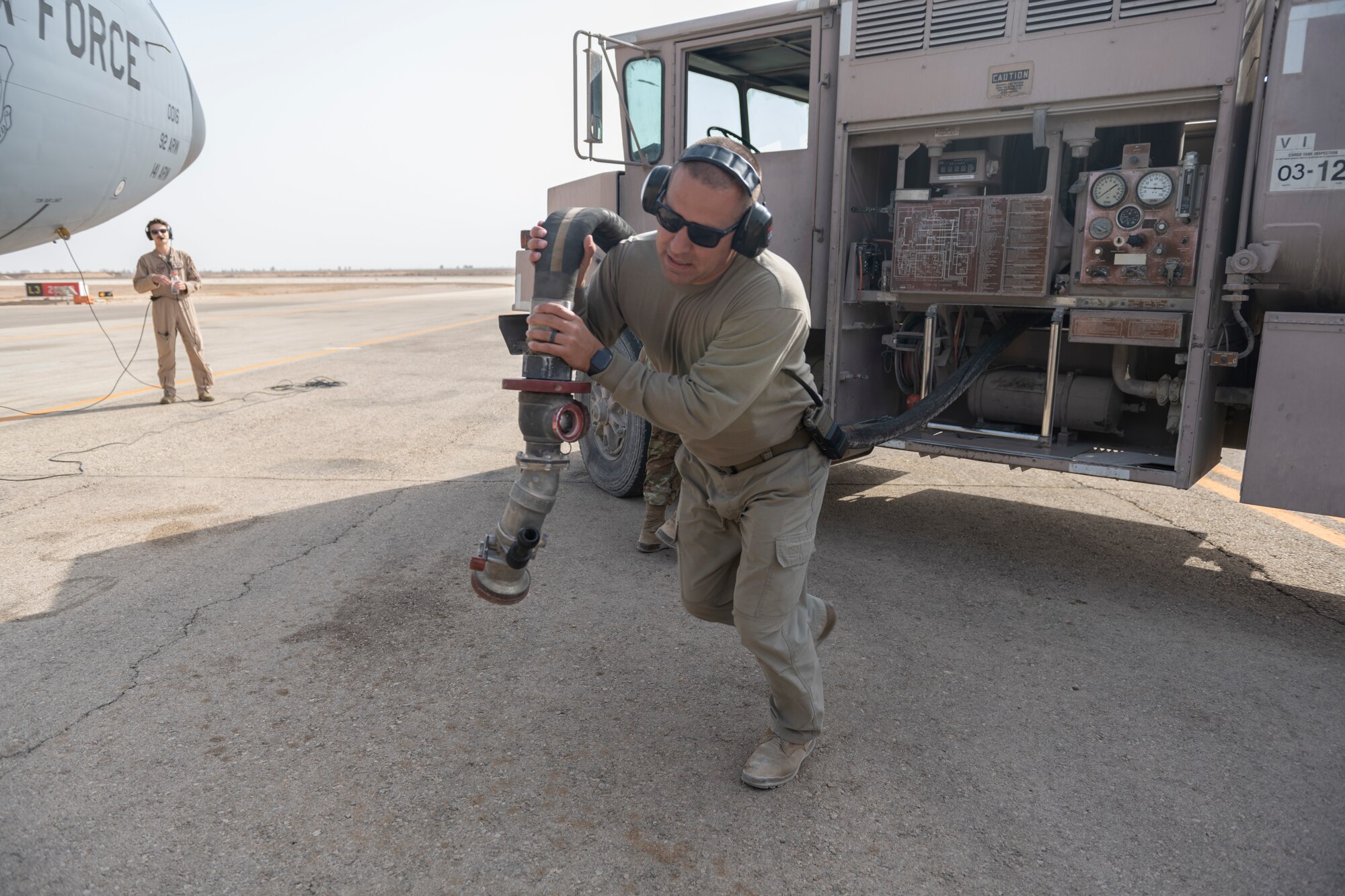 U.S. Air Force Tech. Sgt. Mitchell Madeker, 332nd Expeditionary Logistics Readiness Squadron noncommissioned officer in charge of fuel distribution, pulls a fuel hose out of an R-11 fuel truck