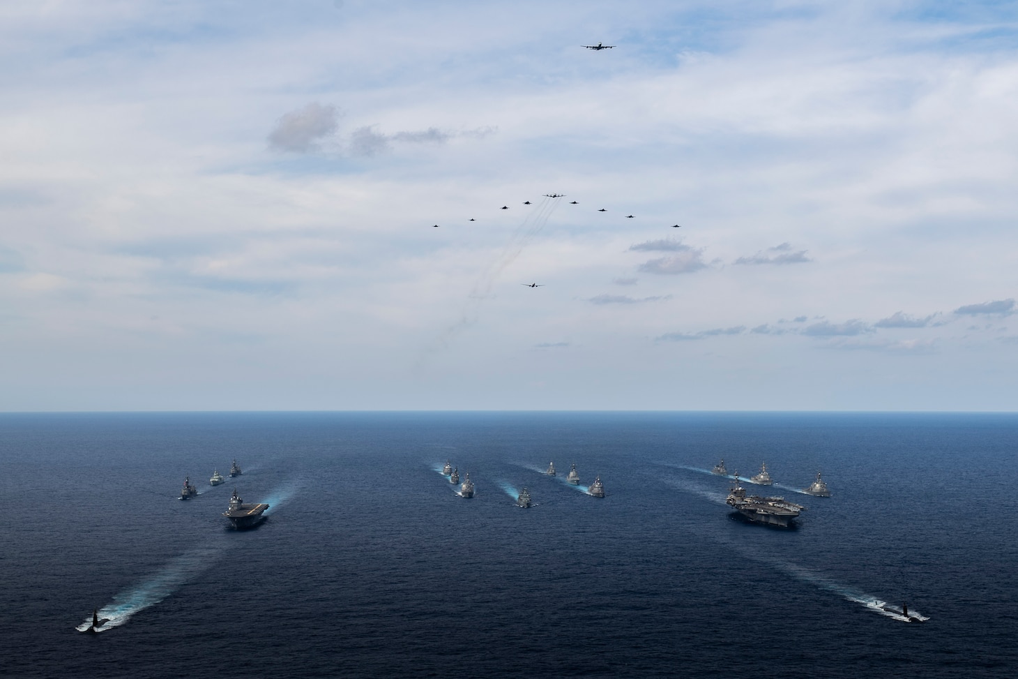 Eleven aircraft fly over 17 ships from the Royal Australian Navy, Royal Canadian Navy, German Navy, Japan Maritime Self-Defense Force (JMSDF) and U.S. Navy as they sail in formation during Annual Exercise (ANNUALEX), Nov. 21. ANNUALEX 2021 is a multilateral exercise conducted by elements of the Royal Australian, Royal Canadian, German, JMSDF and U.S. navies to demonstrate naval inoperability and a joint commitment to a free, open and inclusive Indo-Pacific.