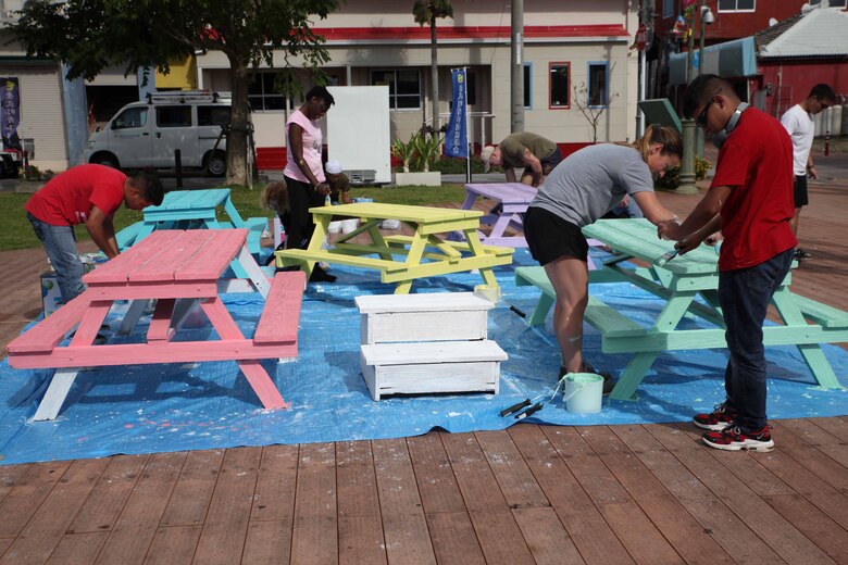 金武町新開地地区の中心に位置するアクティブパークにあるベンチにパステルカラーの塗装を塗る海兵隊員たち、沖縄県金武町、2021年11月20日