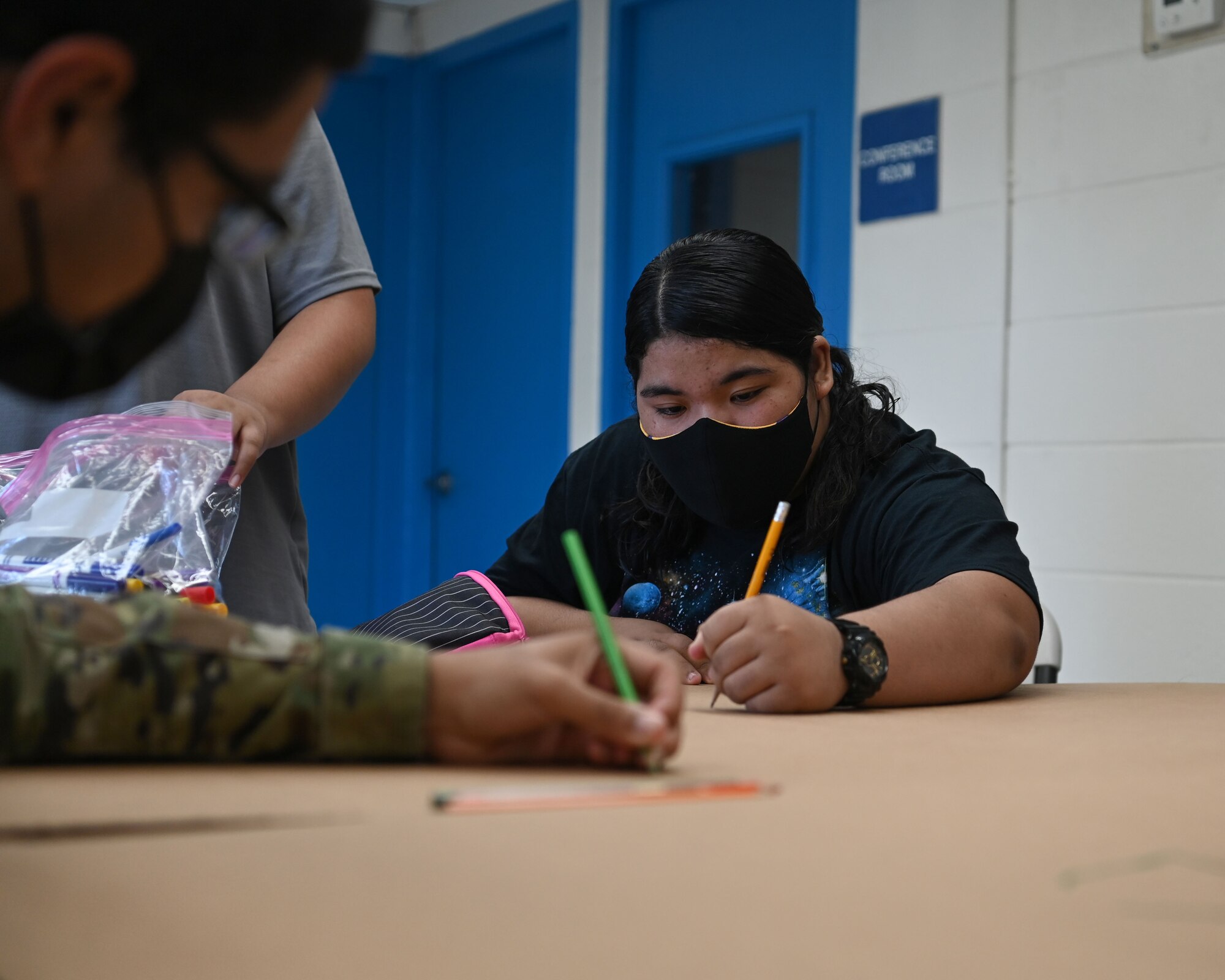 A child with Mañe'lu and U.S. Air Force Airman 1st Class Joshua Thompson, a budget analysis with 36th Comptroller Squadron, draw and write messages on a box during a volunteer event at Toto Garden, Mongmong-Toto-Maite, Nov. 18th, 2021. The two Airmen from 36 CPTS volunteered through Andersen Air Force Base’s Sister Village Sister Squadron program and joined the children with Mañe'lu to decorate boxes that will be used during Operation Christmas Drop with donated supplies. (U.S. Air Force photo by Senior Airman Aubree Owens)