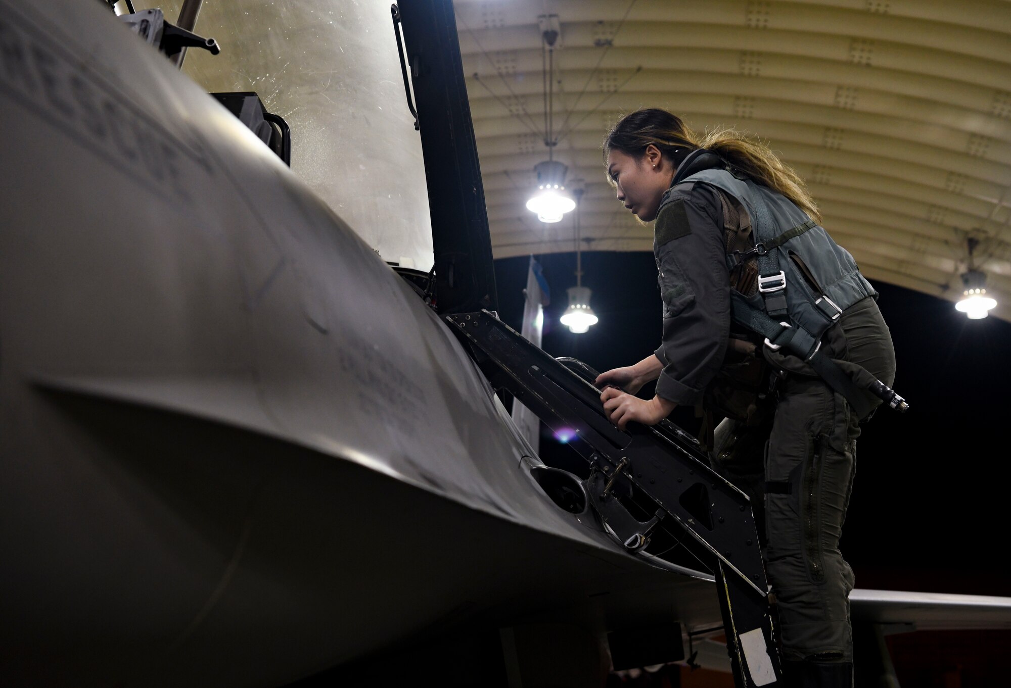 Captain (Doctor) Lisa Choe, 80th Fighter Squadron flight doctor, climbs ladder to get on a F-16 Fighting Falcon at Kunsan Air Base, Republic Of Korea, Nov. 1, 2021. Kunsan’s fighting squadrons lead the combat air forces as the lethal fighter squadrons of motivated, expertly trained warriors focused on the defense of the Republic of Korea and regional stability in the Pacific. (U.S. Air Force photo by Staff Sgt. Jesenia Landaverde)