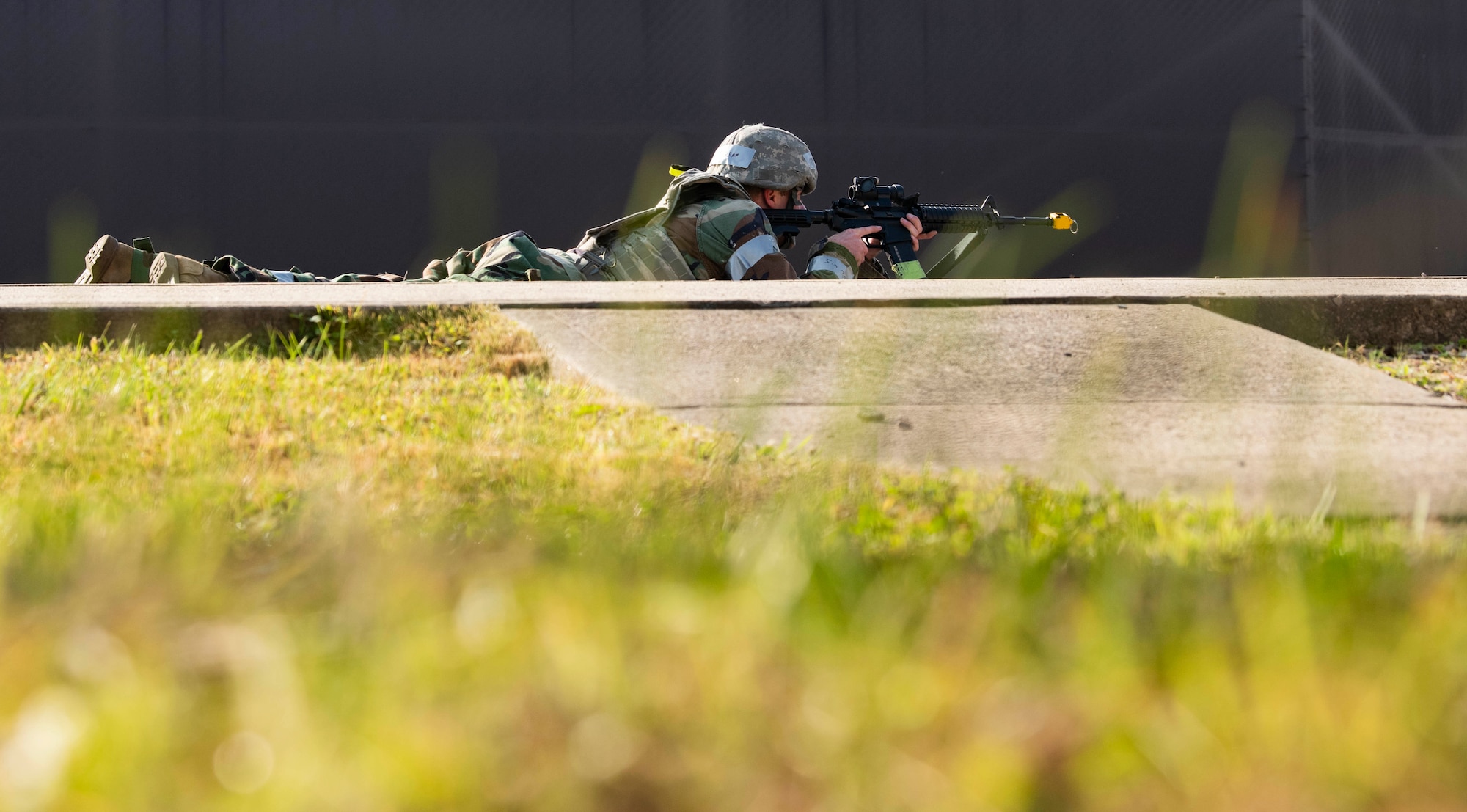 An 8th Security Forces Squadron augmentee provides cover in the prone position during a simulated opposing force attack