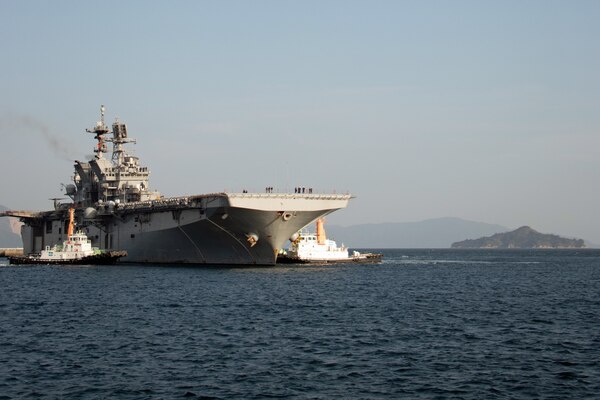 IWAKUNI, Japan (Nov. 18, 2021) USS America (LHA 6), the Navy’s only forward-deployed amphibious assault ship, pulls into the harbor at Marine Corps Air Station Iwakuni. Due to its geographic location and collocated airfield and harbor, MCAS Iwakuni is uniquely postured to provide advanced naval integration in support of regional security. America, flagship of the America Expeditionary Strike Group is operating in the U.S. 7th Fleet area of responsibility to enhance interoperability with allies and partners, and serves as a ready response force to defend peace and stability in the Indo-Pacific region. (U. S. Marine Corps photo by Staff Sgt. Jessika Braden)