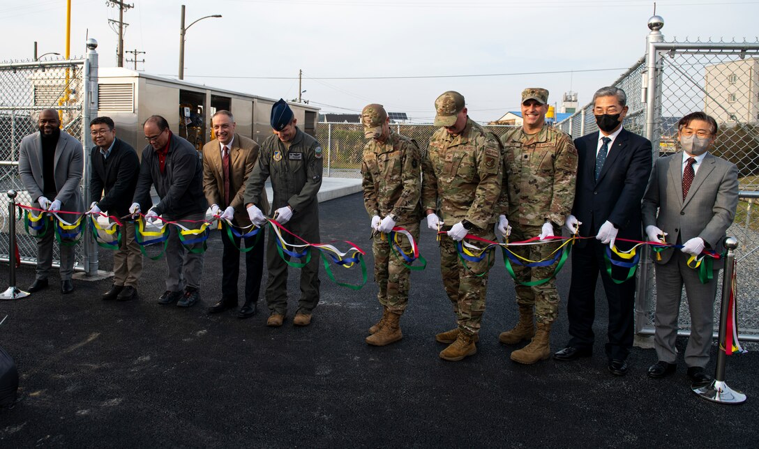 Leadership from the 8th Fighter Wing stand alongside members from the 411th Contracting Support Brigade, Honeywell, Gunsan City Gas Corporation as they cut the ceremonial ribbon for the natural gas pipeline installed at Kunsan Air Base, Republic of Korea, Nov. 15, 2021. The pipeline is now providing heating to two dormitories that house approximately 450 Airmen. (U.S. Air Force photo by Staff Sgt. Suzie Plotnikov)