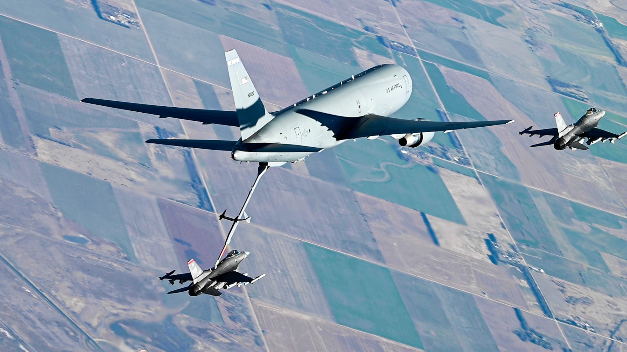 A KC-46A Pegasus from Pease Air National Guard Base N.H., with a mixed crew from four Major Commands refuel an F-16 Fighting Falcon assigned to 138th Fighter Wing, Tulsa Air National Guard Base, Oklahoma, Nov. 18, 2021. Aircrews from McConnell AFB, Altus AFB, Oklahoma, and Pease, combined their efforts to plan a Weapons System Council to execute a three-ship local KC-46 sortie. (U.S. Air Force photo by Airman 1st Class Zachary Willis)