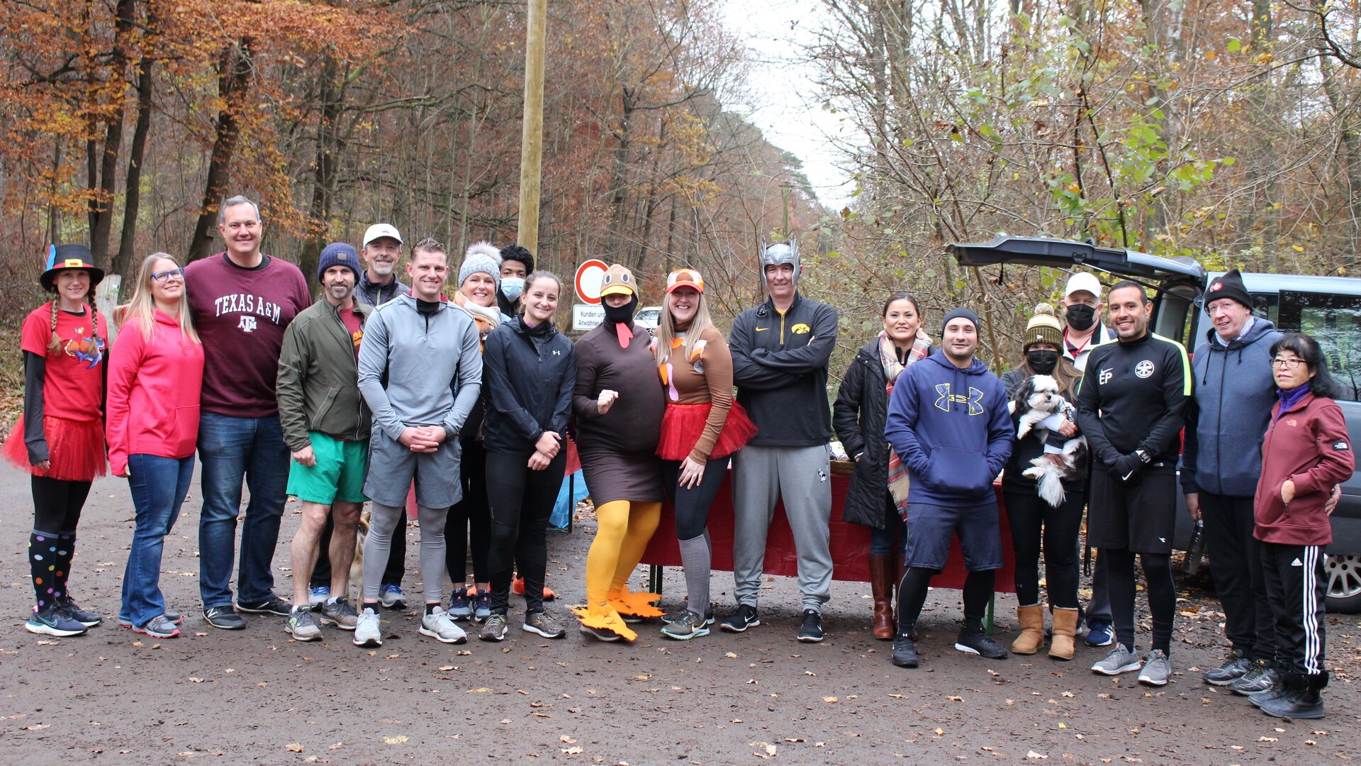 A group of people stand together on a path in the woods.