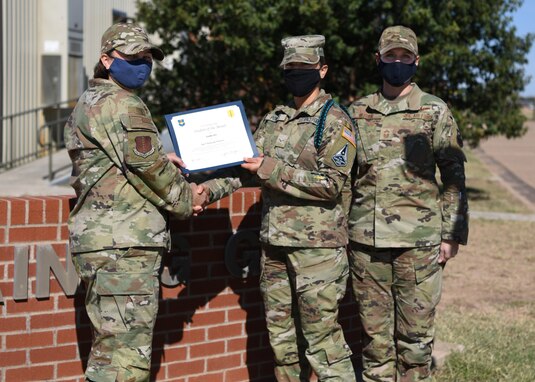 U.S. Air Force Col. Angelina Maguinness, 17th Training Group commander, presents U.S. Space Force Specialist 3 Hannah Powers, 316th Training Squadron student, the 17th TRG Rope of the Month award for October 2021, on Goodfellow Air Force Base, Texas, Nov. 19, 2021. The 316th TRS is responsible for training, developing and inspiring intelligence, surveillance and reconnaissance cryptologic leaders. (U.S. Air Force photo by Airman 1st Class Sarah Williams)