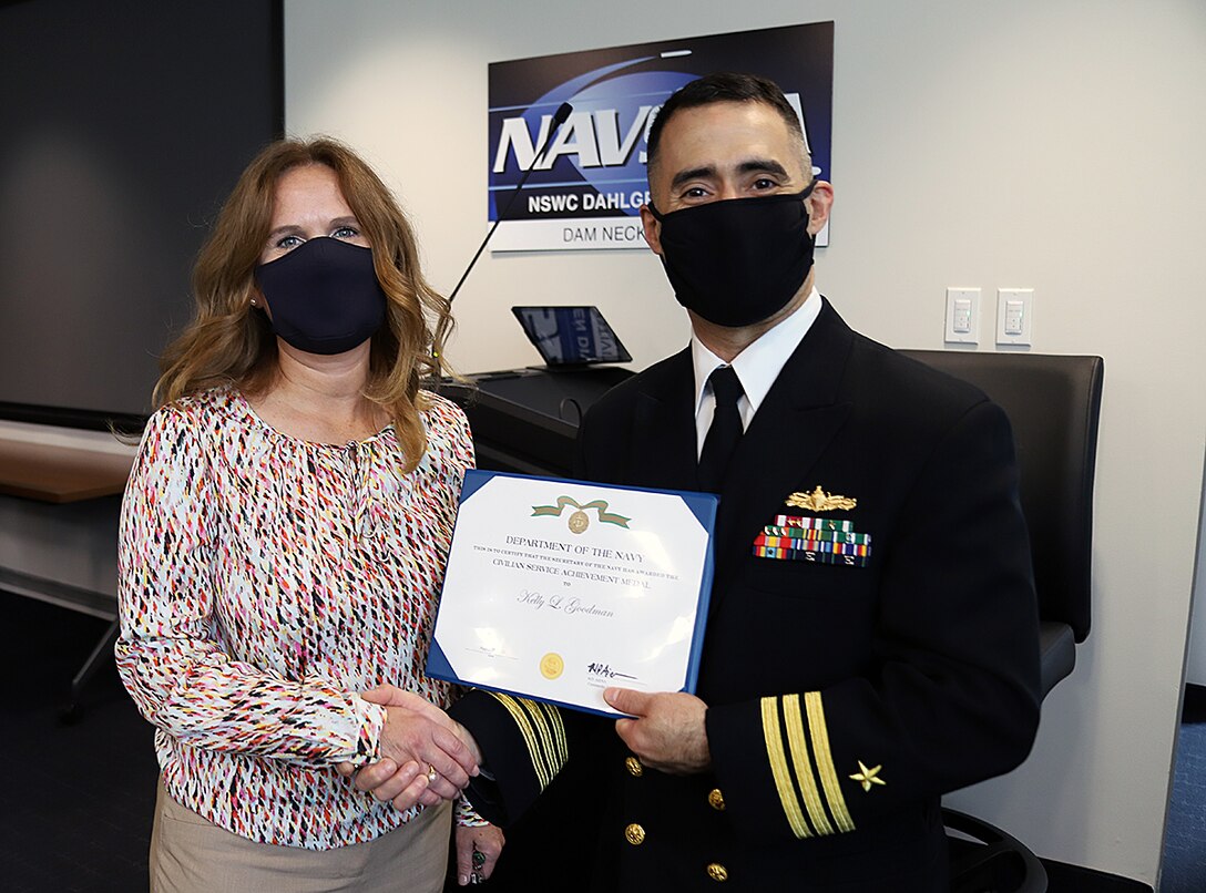 IMAGE: Naval Surface Warfare Center Dahlgren Division Dam Neck Activity (NSWCDD DNA) Commanding Officer Cmdr. Michael Aiena presents Kelly Goodman with a Department of Navy Civilian Service Achievement Medal Oct. 13, in Virginia Beach, Virginia. Goodman, NSWCDD DNA chief information officer and Information Technology division head, received the award for providing exemplary leadership in preparing her division for a triennial Immediate Superior in Command-led Inspector General audit of the division's Cybersecurity programs.