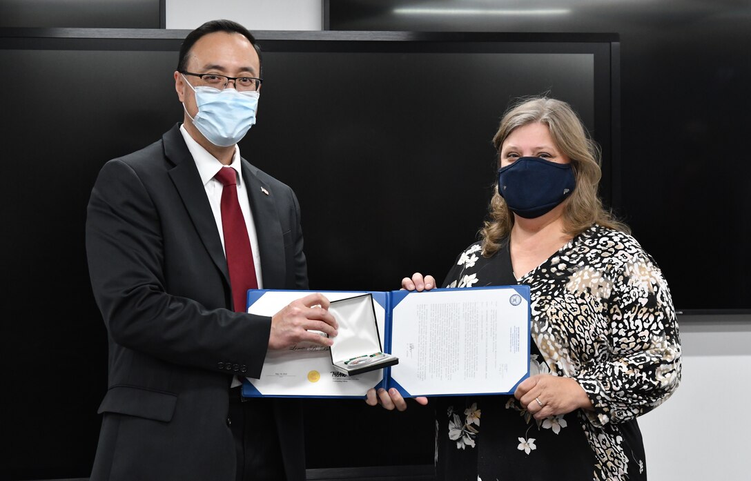 IMAGE: James Yee presents Loretta “Lori” Bowling with her Civilian Service Achievement Medal (CSAM) at a small reception offsite. Bowling is one of eight Naval Surface Warfare Center Dahlgren Division Dam Neck Activity employees to receive the CSAM this year.