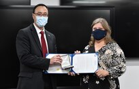 IMAGE: James Yee presents Loretta “Lori” Bowling with her Civilian Service Achievement Medal (CSAM) at a small reception offsite. Bowling is one of eight Naval Surface Warfare Center Dahlgren Division Dam Neck Activity employees to receive the CSAM this year.