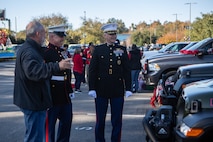 Telly Carver, left, a member of Muddy Crawlers Jeep Club, Onslow County, North Carolina, speaks with U.S. Marine Corps Sgt. Maj. Douglas W. Gerhardt, center, sergeant major, MCAS New River, and Col. Curtis V. Ebitz, Jr, right, commanding officer, MCAS New River, before the 2021 Christmas Holiday Parade in Jacksonville, North Carolina, Nov. 20, 2021.