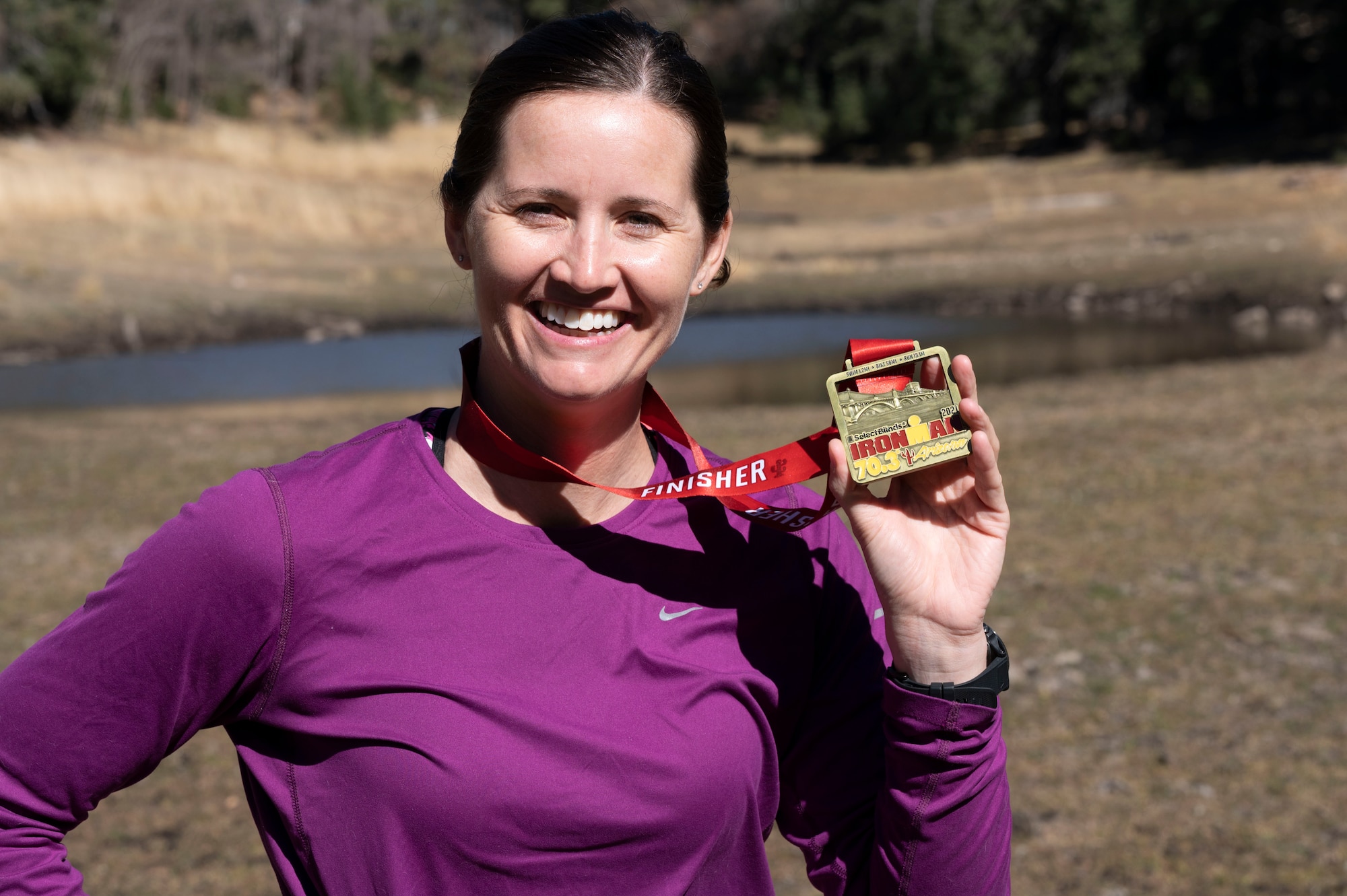 1st Lt. Ashley Corkins, 49th Wing junior executive officer, displays her Ironman 70.3 medal in Cloudcroft, New Mexico, Nov. 13, 2021. After six months of intense training, Corkins was able to finish her first Ironman 70.3 triathlon, and was awarded a medal after crossing the finish line. (U.S. Air Force photo by Airman 1st Class Antonio Salfran)