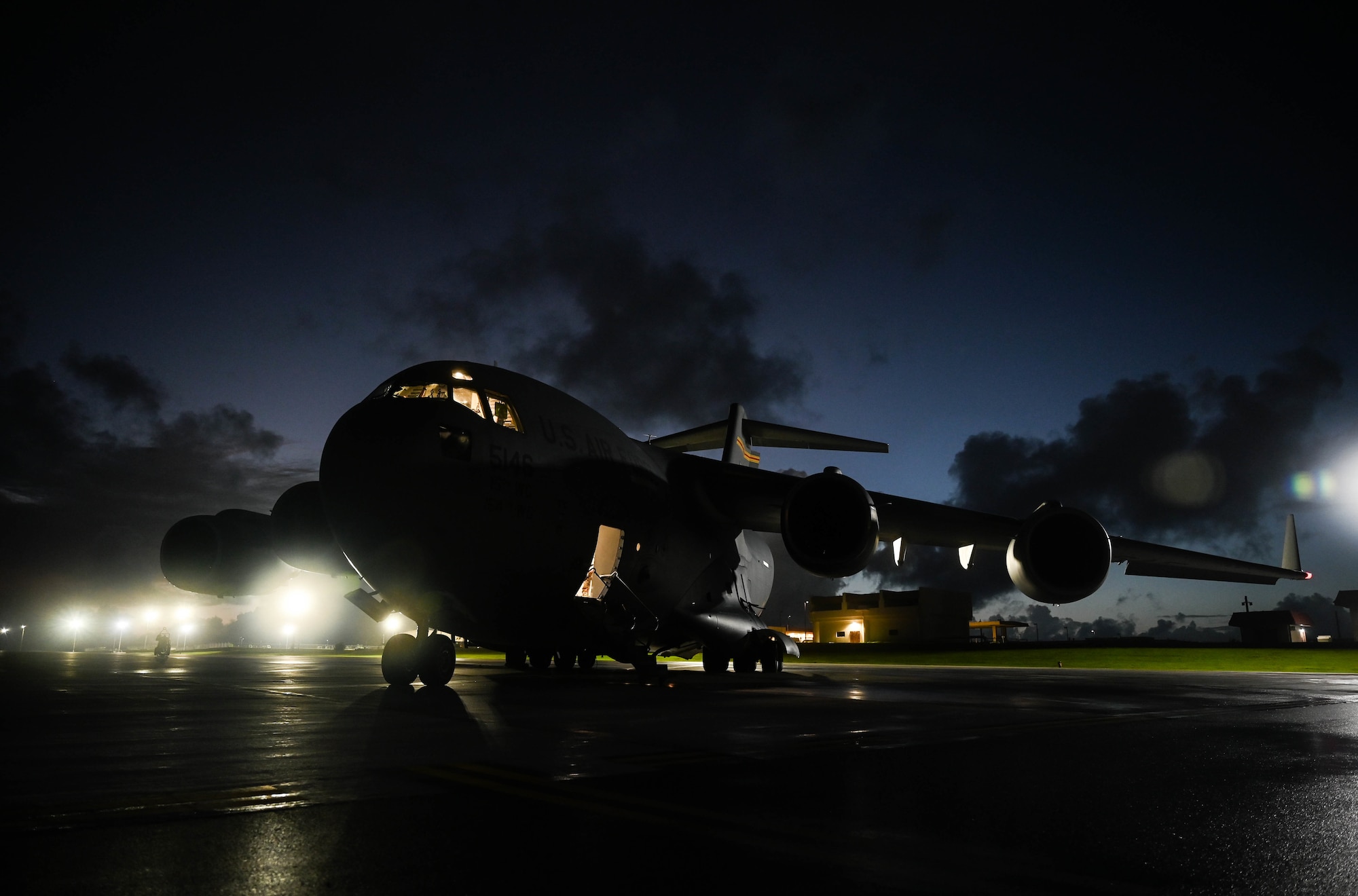 A C-17A Globemaster III, assigned to Joint Base Pearl Harbor-Hickam, Hawaii, sits on the flightline during preflight checks at Andersen Air Force Base, Guam, Nov. 14, 2021. The JBPHH aircrew participated in a training exercise with two C-17s assigned to the Royal Australian Air Force, enhancing joint operation capabilities in the Indo-Pacific. (U.S. Air Force photo by Staff Sgt. Alan Ricker)