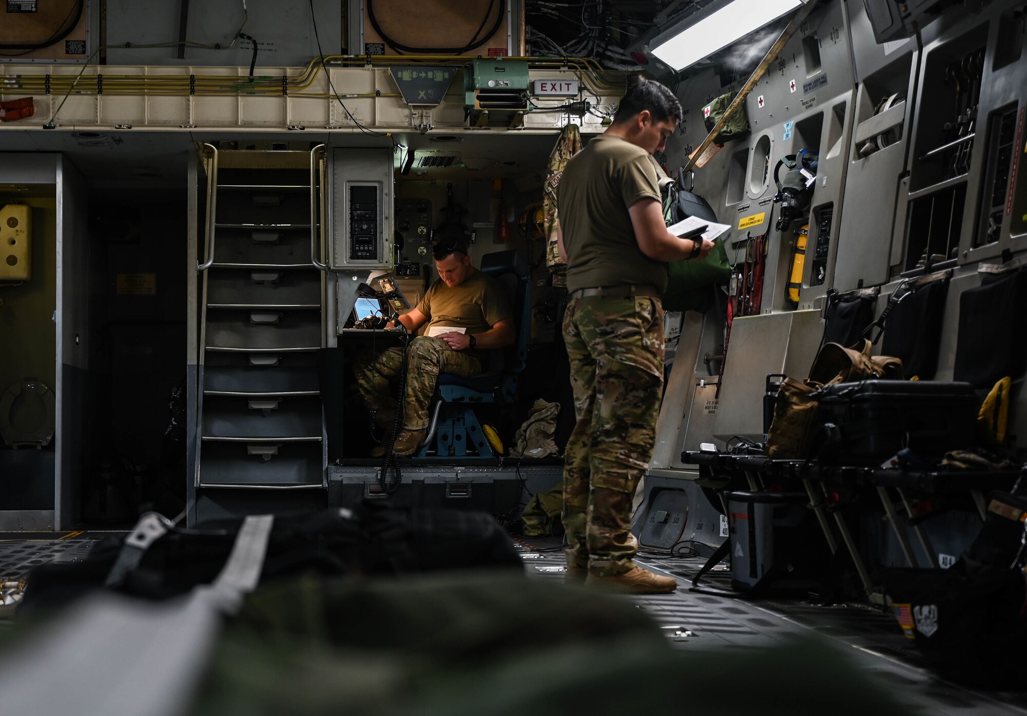Tech. Sgt. William Seyler, 535th Airlift Squadron loadmaster, and Airman 1st Class Layne Fitzpatrick, 535th AS loadmaster, perform preflight checks in a C-17A Globemaster III at Andersen Air Force Base, Guam, Nov. 14, 2021. The Joint Base Pearl Harbor-Hickam, Hawaii, aircrew participated in joint training operations alongside two Royal Australian Air Force C-17s, increasing airframe interoperability between the two allies. (U.S. Air Force photo by Staff Sgt. Alan Ricker)