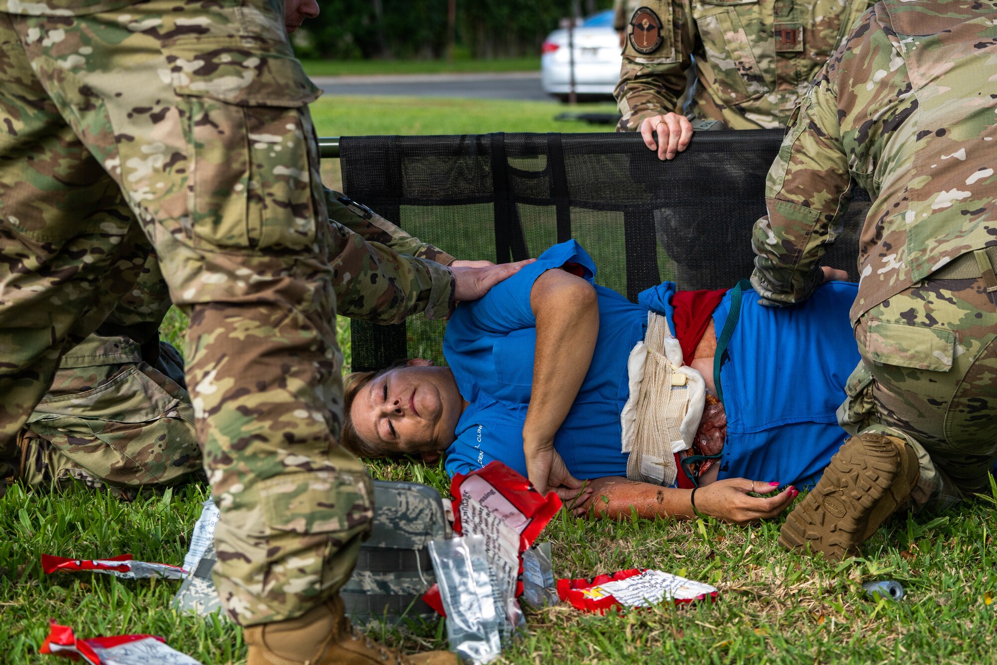 Airmen from the 15th Medical group tend to simulated patient, Daria Day, 15th Medical Group deployment-related health assessment contractor, during a mass-casualty exercise at Joint Base Pearl Harbor-Hickam, Hawaii, Nov. 18, 2021. The injured simulated victims had fake wound kits, and fake blood and portrayed the distress of the situation by screaming and being unresponsive. (U.S. Air Force photo by Airman 1st Class Makensie Cooper)