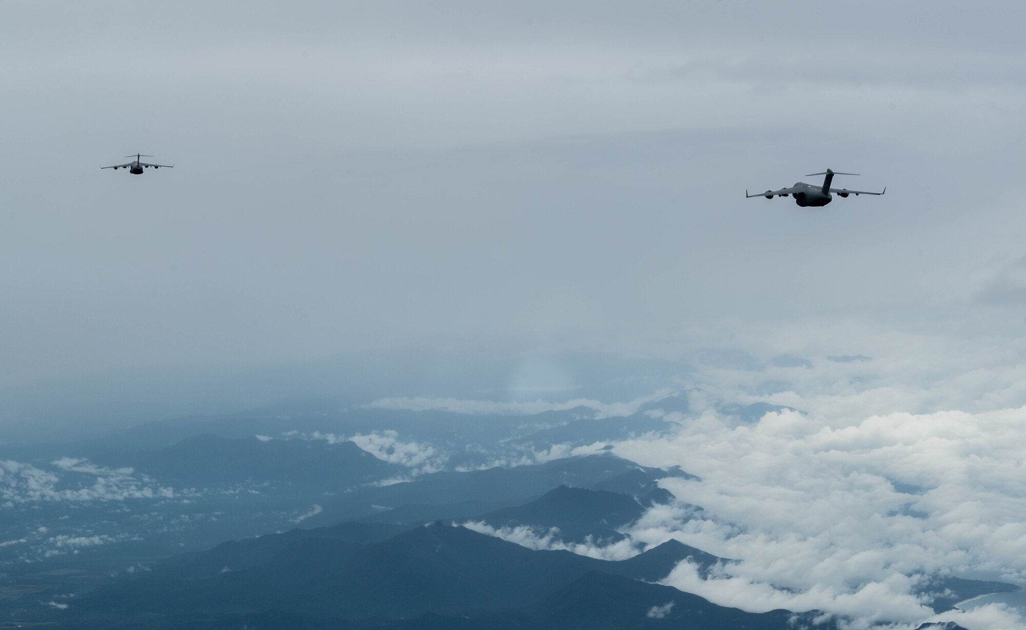 Two Royal Australian Air Force C-17A Globemaster IIIs assigned to Joint Base Pearl Harbor-Hickam, Hawaii, conduct a training exercise over the West Pacific, Nov. 14, 2021. Exercises between the United States Air Force and the RAAF increase both countries’ potential to coordinate and perform joint-aerial operations. (U.S. Air Force photo by Staff Sgt. Alan Ricker)