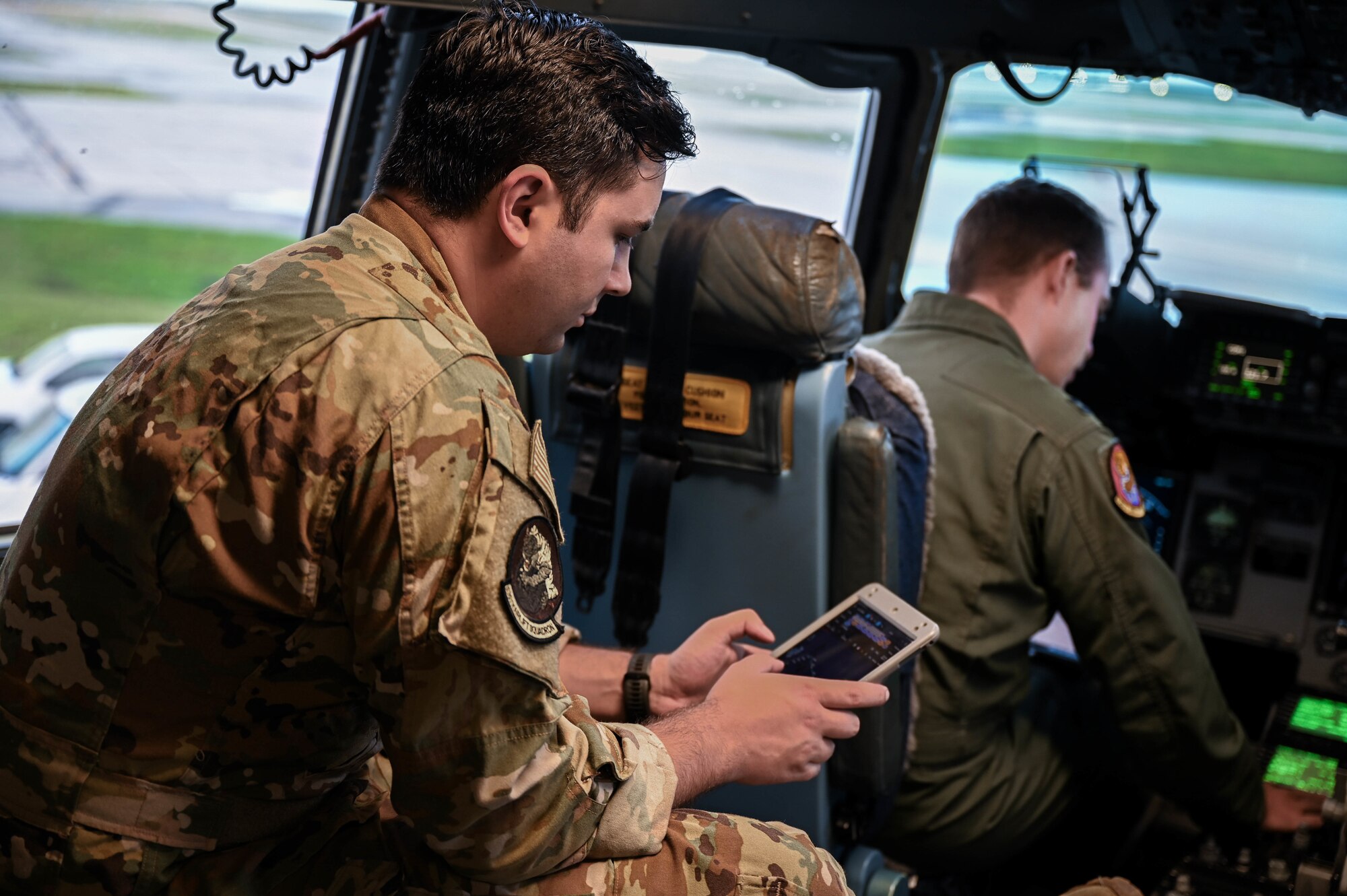 1st Lt. Michael Knab, 535th Airlift Squadron C-17A Globemaster III co-pilot, reviews flight plans while Capt. Alec Nelson, 535th AS C-17 aircraft commander, performs preflight checks at Andersen Air Force Base, Guam, Nov. 14, 2021. The Joint Base Pearl Harbor-Hickam, Hawaii, aircrew participated in a three-ship formation and performed simulated high-altitude drops with Royal Australian Air Force C-17s over the West Pacific. (U.S. Air Force photo by Staff Sgt. Alan Ricker)