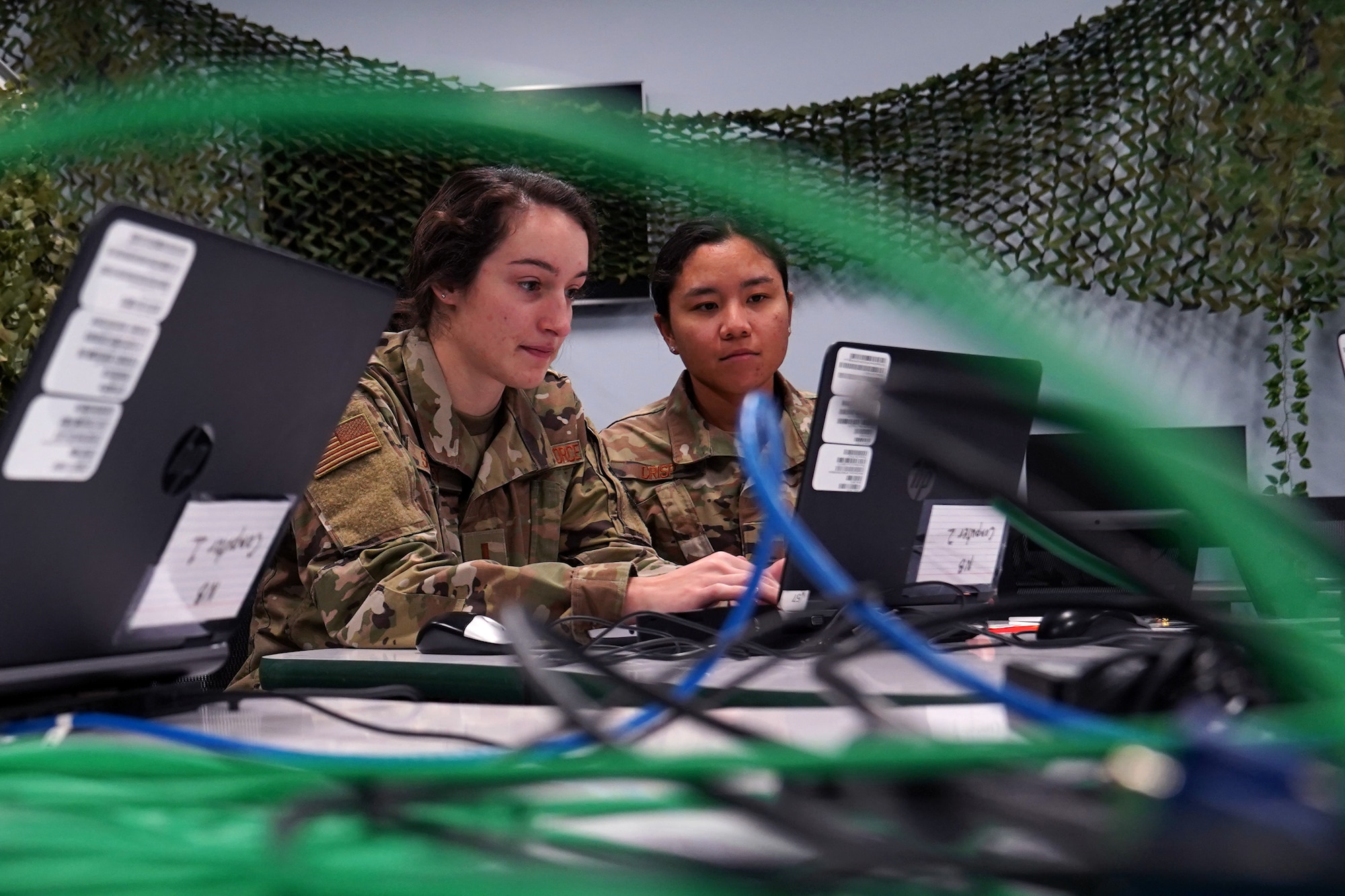U.S. Air Force 2nd Lt. Alexis Shirley and 2nd Lt. Trisha Crisp, 333rd Training Squadron cyber warfare officers, complete cyber tasks in the cyber escape room inside Stennis Hall at Keesler Air Force Base, Mississippi, November 10, 2021. The escape room was implemented into the squadron to test the capabilities of cyber warfare students and sharpen their skillset. (U.S. Air Force photo by Senior Airman Seth Haddix)