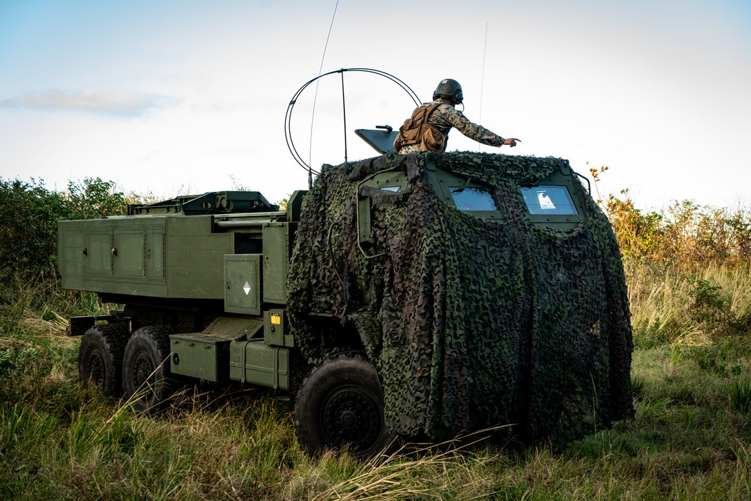 U.S. Marines with 3d Battalion, 12th Marines, 3d Marine Division, move to a firing position during a High Mobility Artillery Rocket System rapid aerial insertion mission at Iwo To, Japan, Nov. 1, 2021. Upon landing, Marines swiftly moved to a concealed position and prepared to engage simulated targets. The training demonstrated 3d Marine Division’s ability to quickly deploy long range precision fires capabilities to key maritime terrain across the Indo-Pacific region. (U.S. Marine Corps photo by Lance Cpl. Ujian Gosun)