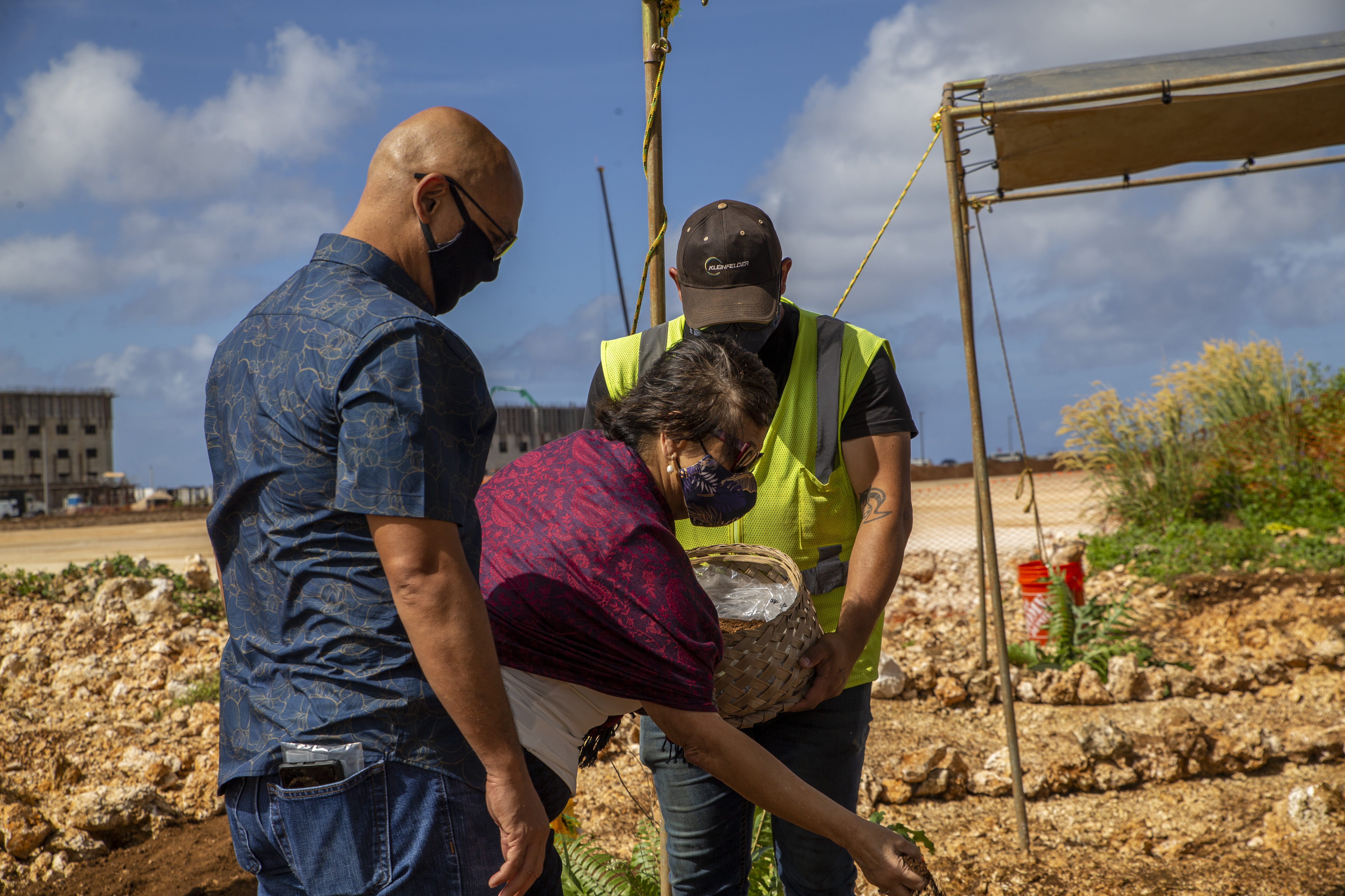 The Honorable Lourdes Leon Guerrero, the governor of Guam, center, places dirt in a burial mound during a cultural ritual at the Sabånan Fadang burial site on Marine Corps Base Camp Blaz, Nov. 23, 2021.