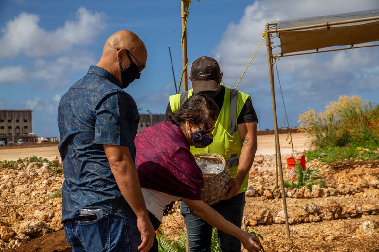 The Honorable Lourdes Leon Guerrero, the governor of Guam, center, places dirt in a burial mound during a cultural ritual at the Sabånan Fadang burial site on Marine Corps Base Camp Blaz, Nov. 23, 2021.