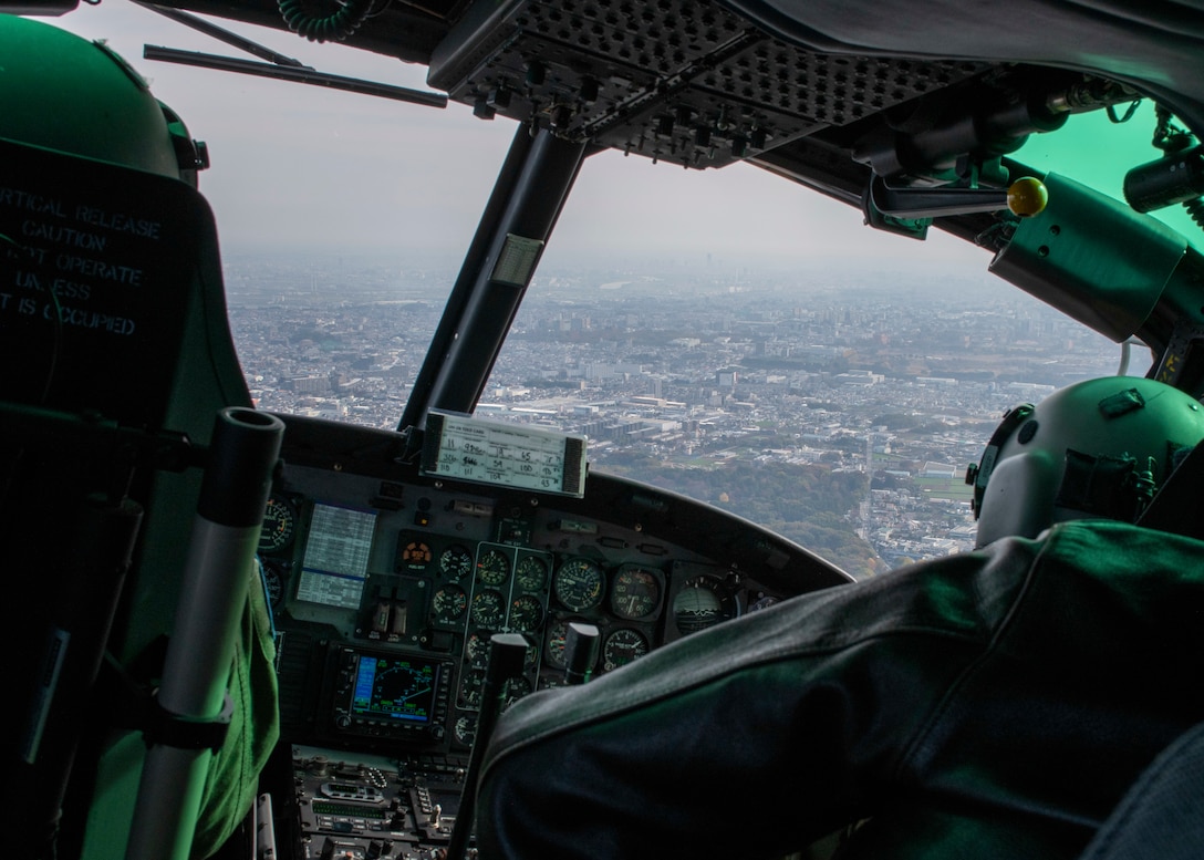 A helicopter flies over a dense metro area.