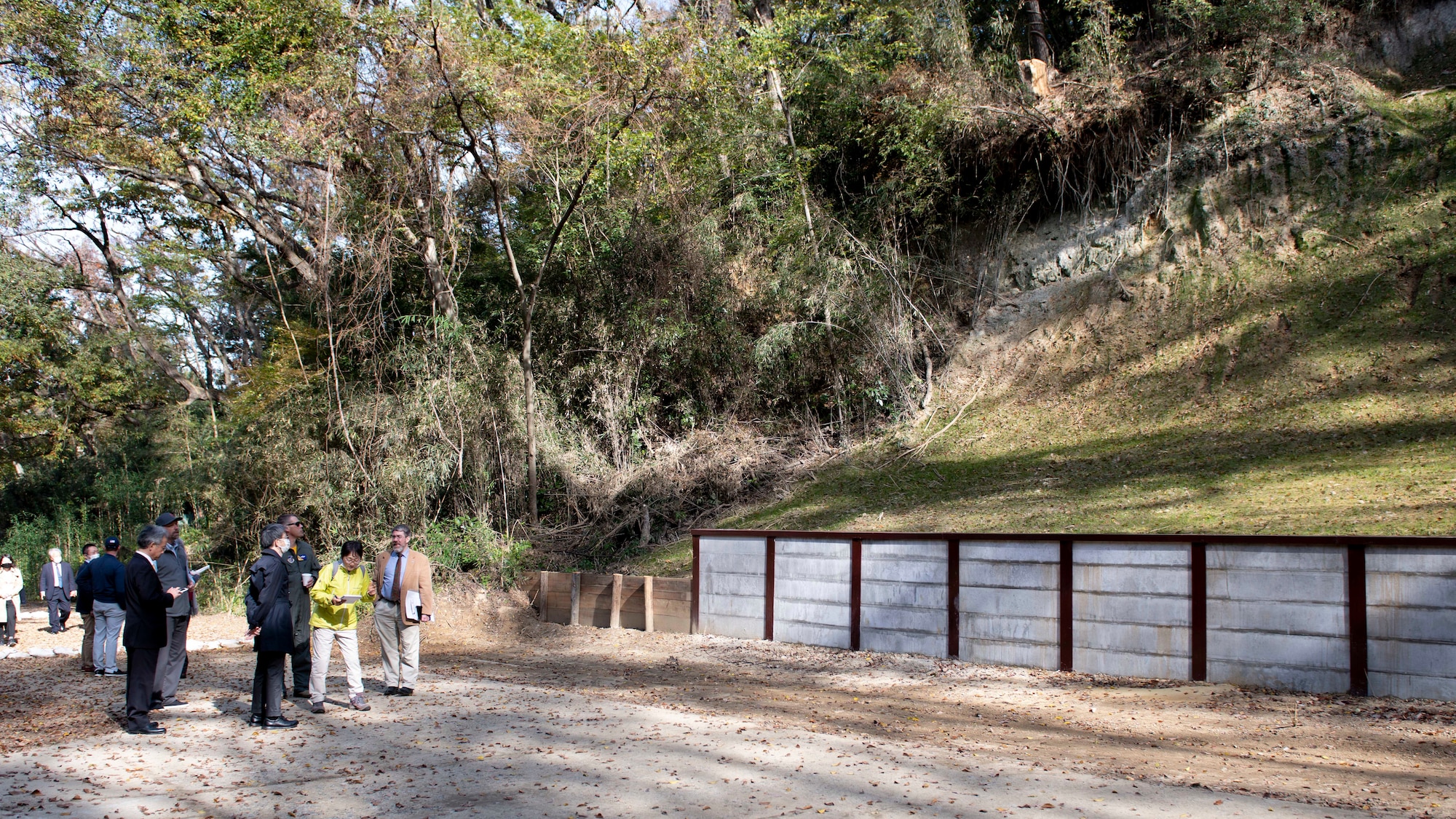 A group of U.S. and Japanese officials tour a forested area of Tama Hills.