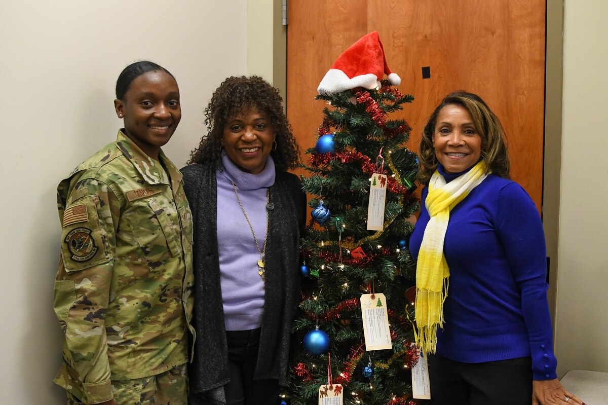 Staff Sgt. Briana Staples and Master Sgt. (Ret.) Jeannette Anderson, both volunteers with the Airman and Family Readiness Center and Jane Esprit, program manager, Airmen and Family Readiness Center host the 2021 Giving Tree Program to help airmen in need this holiday season.