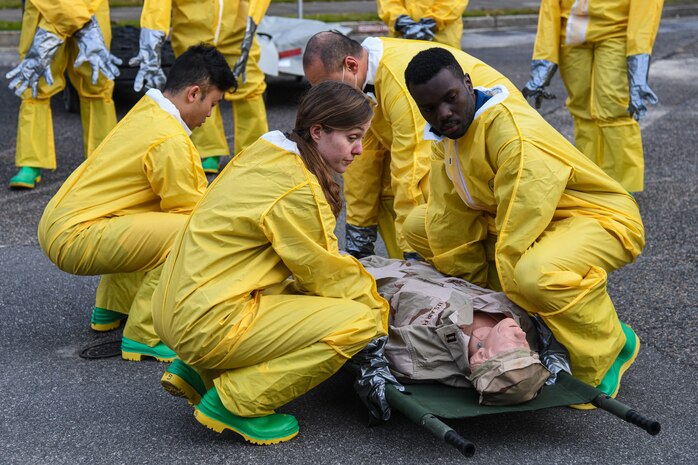 Airmen assigned to the 628th Medical Group lift a simulated patient during a Decontamination Training Exercise at Joint Base Charleston, S.C., Nov. 4, 2021.