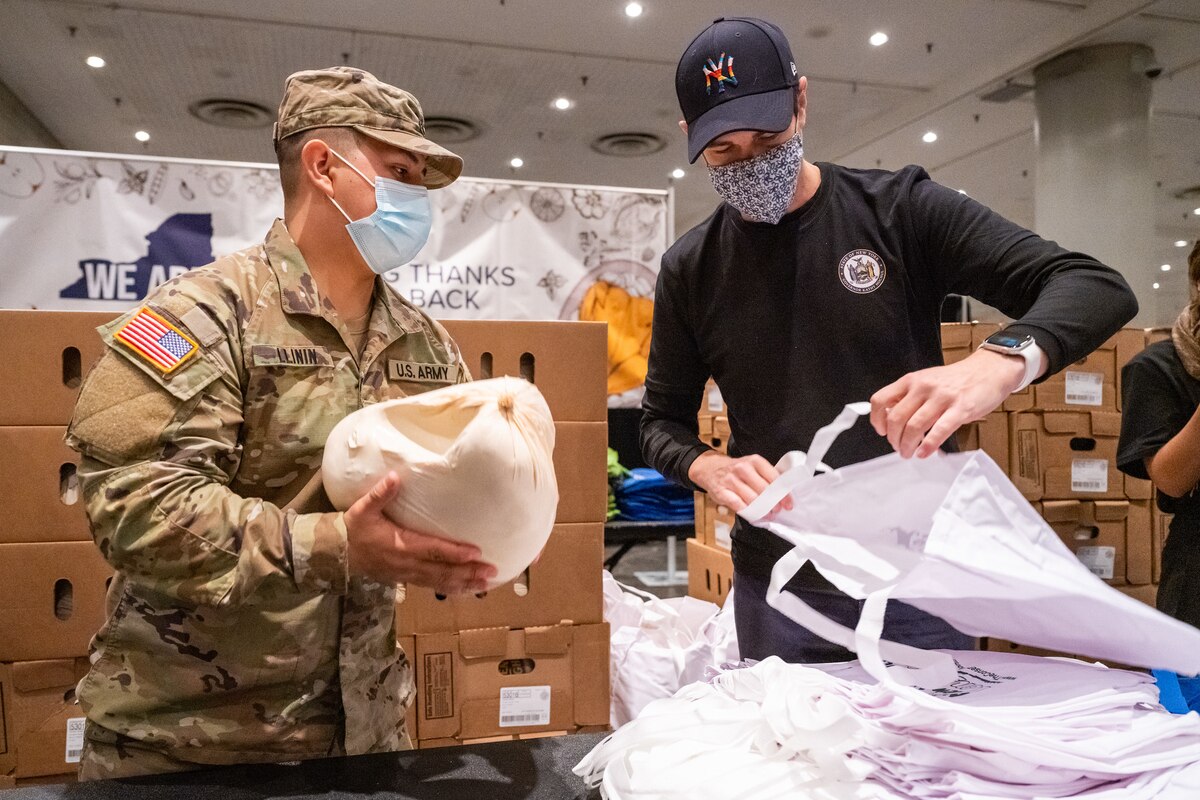 New York Army National Guard Staff Sgt. Jonathan Llinin, serving with Joint Task Force Empire Shield, assists state volunteers in packaging Thanksgiving turkeys for distribution to families across the state at the Jacob Javits Convention Center in New York City November 22, 2021. The New York National Guard provided more than 50 Soldiers and Airmen to assist in the packaging of 3,200 turkeys for families experience food insecurity through the corporate donations of more than $100,000 for the Thanksgiving holiday at food pantries supported by Feed New York State. Photo courtesy of Darren McGee, Office of Governor Kathy Hochul.