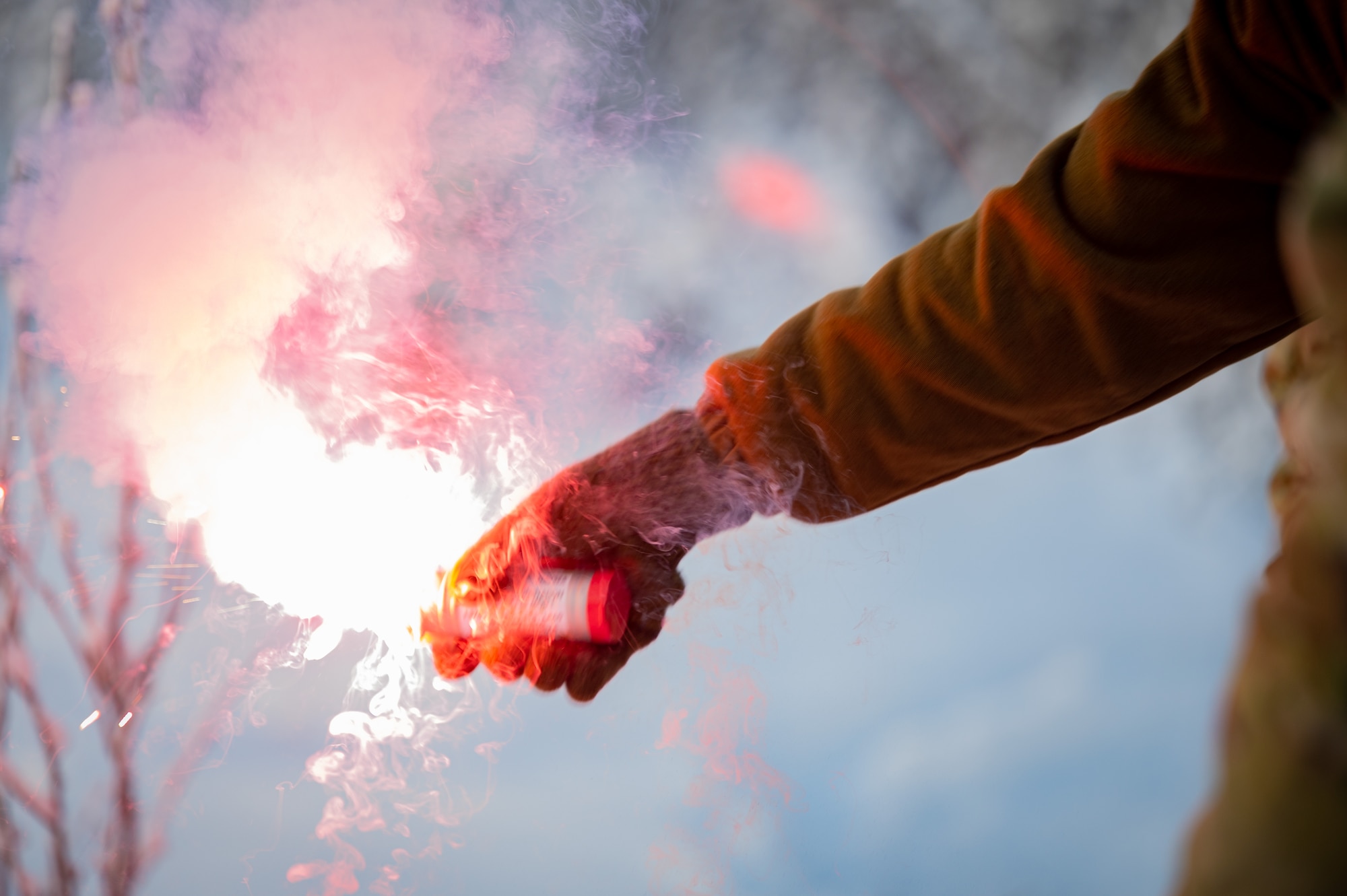 U.S. Air Force Staff Sgt. Samuel Ley, a Survival, Evasion, Resistance and Escape specialist assigned to the Arctic Survival Training School, lights up an MK-124 smoke and illumination flare during a recovery exercise on Eielson Air Force Base, Alaska, Nov. 18, 2021.